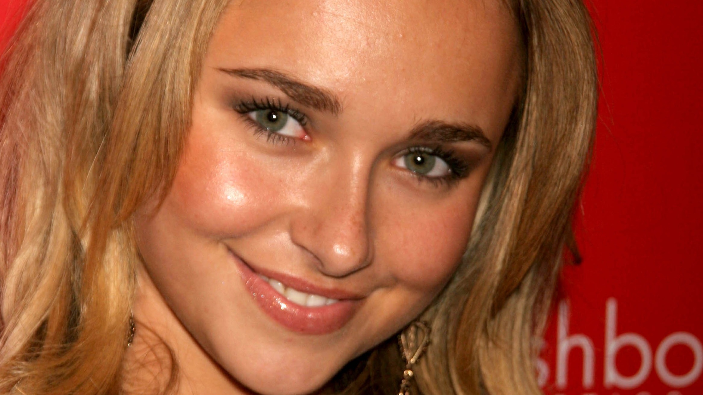 Hayden Panettiere wearing red dress, smiling and looking at camera on red background - 2006