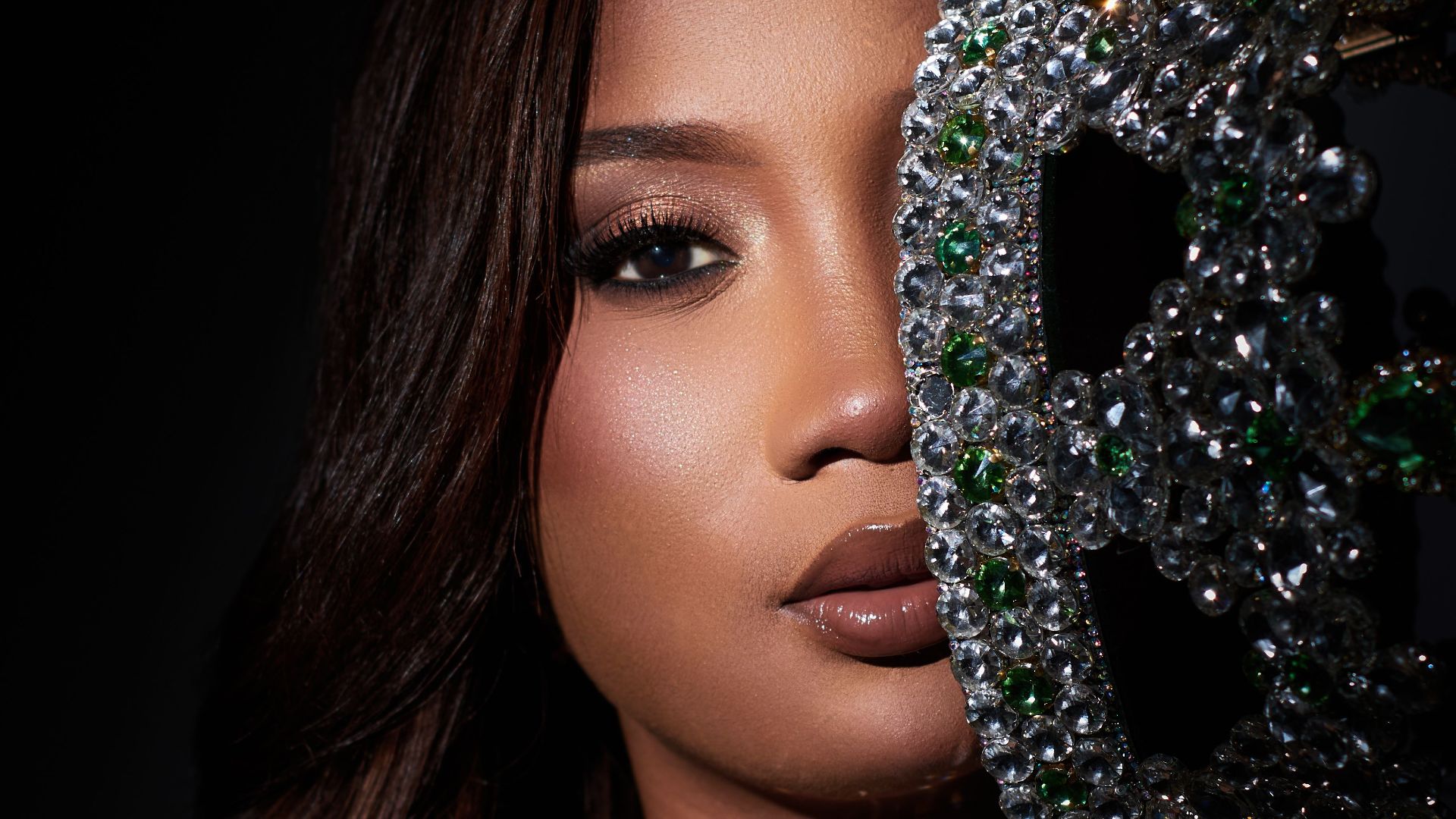 Elegant portrait of a woman with a jeweled crown in dramatic lighting.