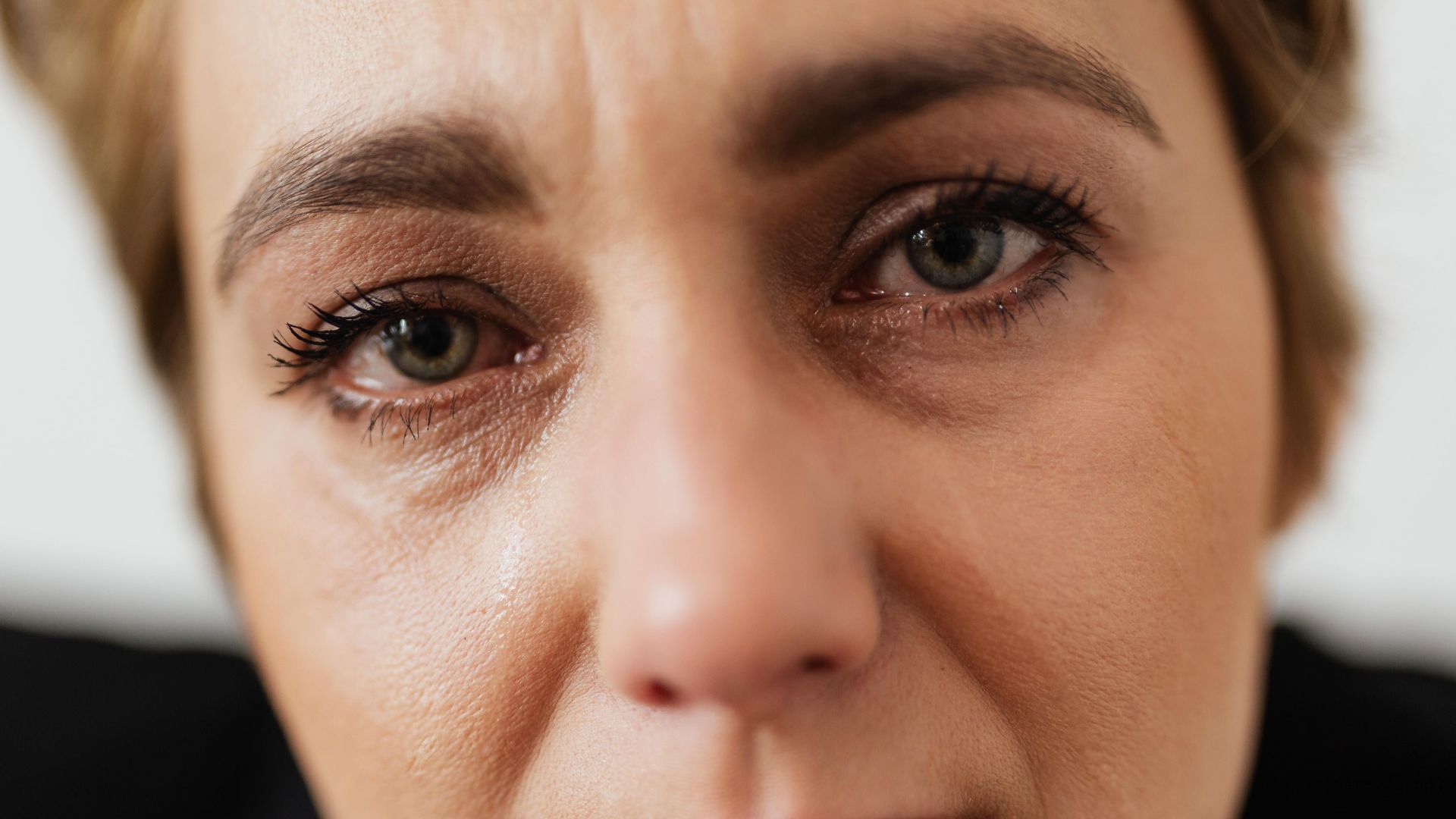 Close-up portrait of a distressed woman showing emotion and vulnerability, emphasizing mental health themes.