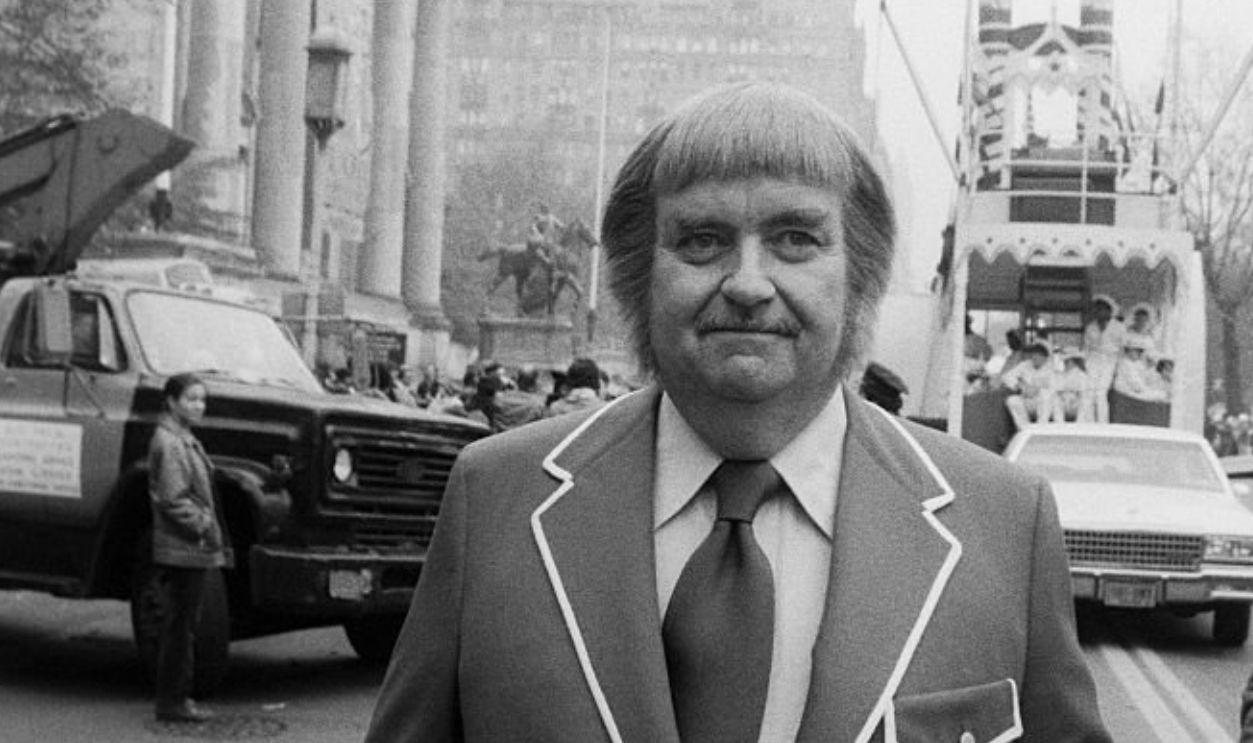 Bob Keeshan, Captain Kangaroo, in jacket with white piping. Float in the background; circa 1980; New York.