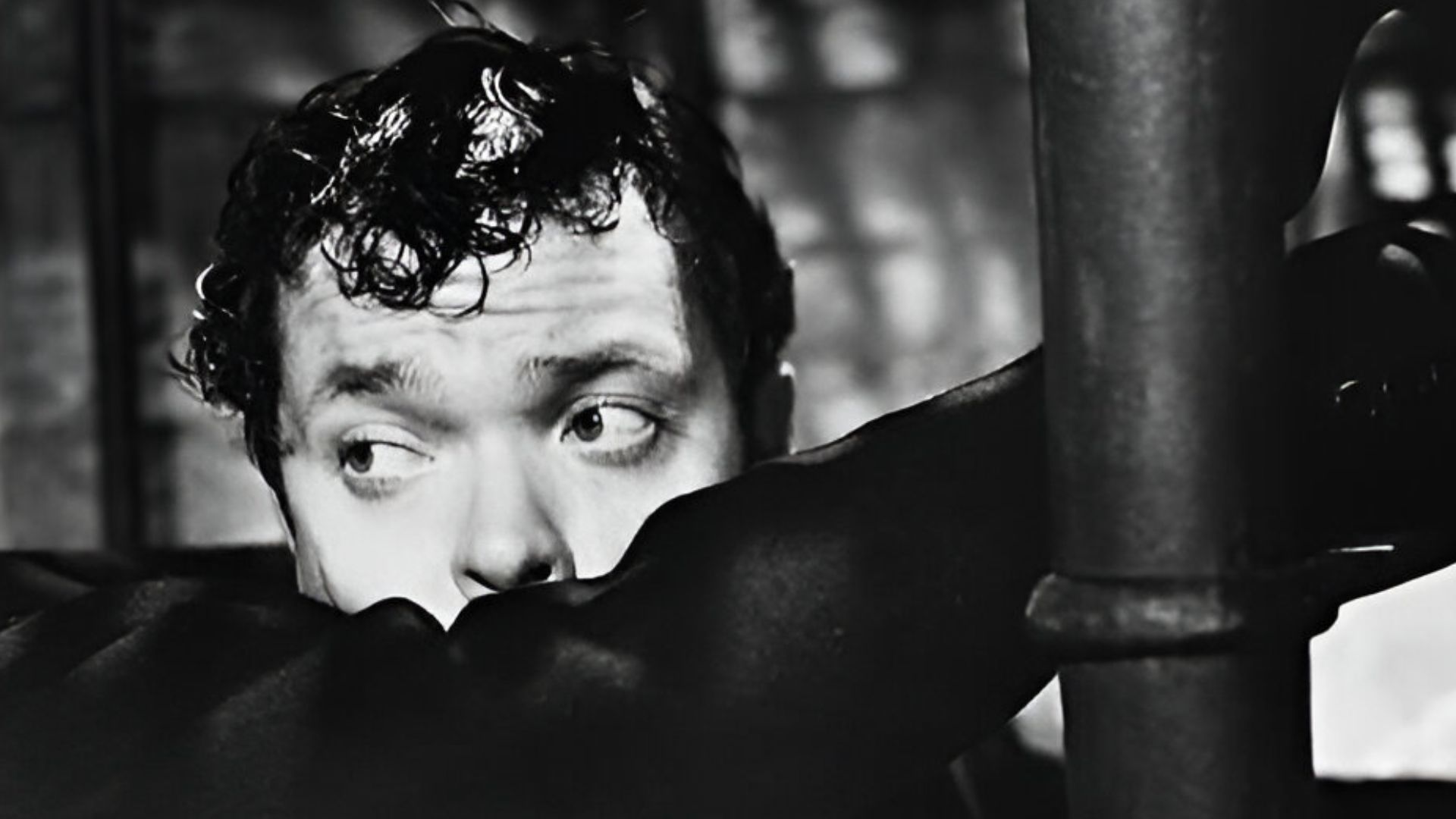 Orson Welles portraying Harry Like in The Third Man, loosely holding a Webley Mk IV Duty Model while climbing a staircase.