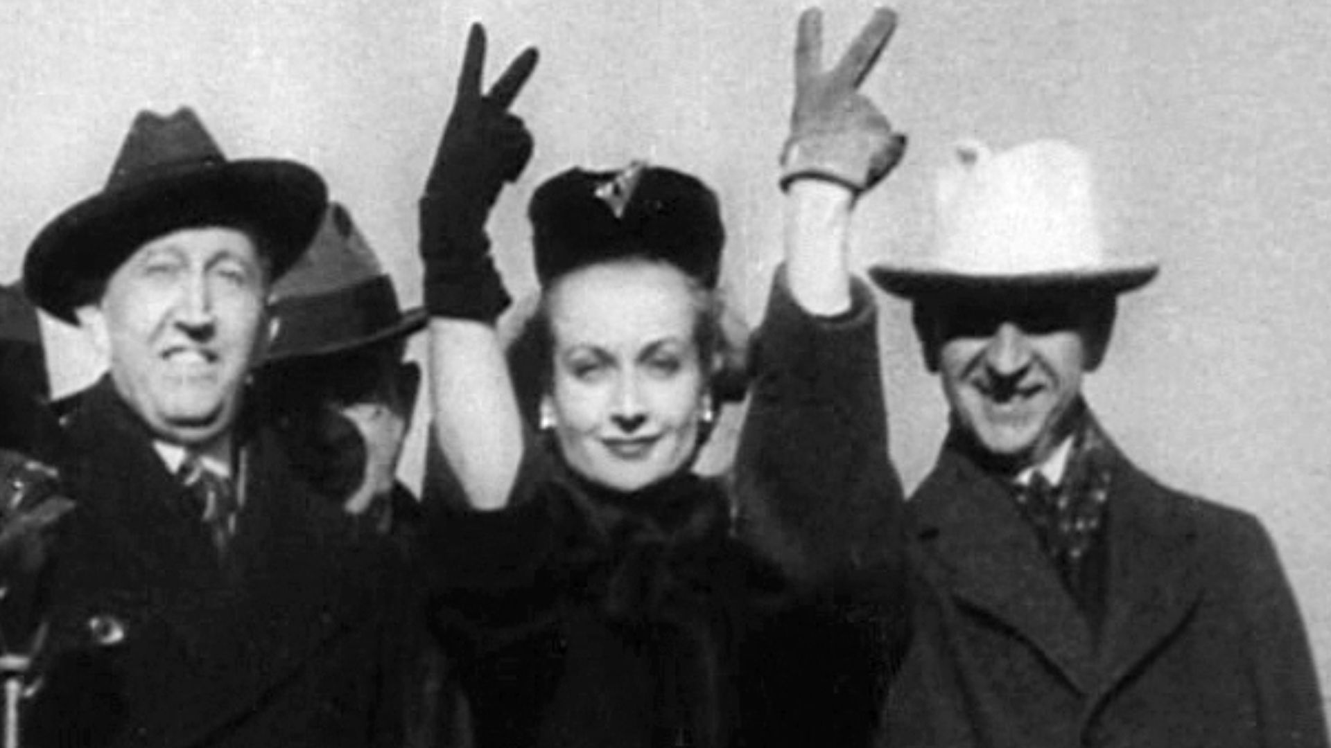 Screenshot of Carole Lombard in Indianapolis with Will H. Hays and Indiana Governor Henry F. Schricker on January 15, 1942, during a war bond tour