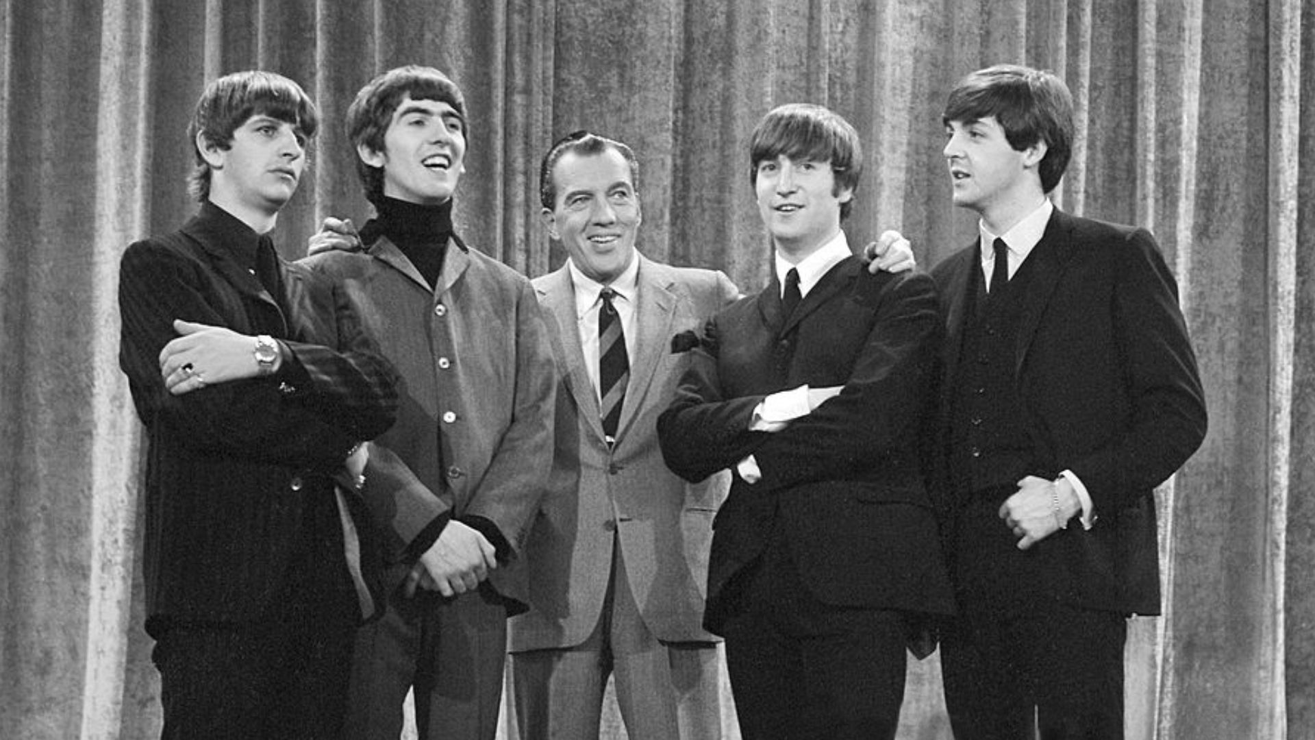 Photo of the Beatles with Ed Sullivan from their first appearance on Sullivan's US variety television program in February 1964.  From left: Ringo Starr, George Harrison, Ed Sullivan, John Lennon, Paul McCartney.