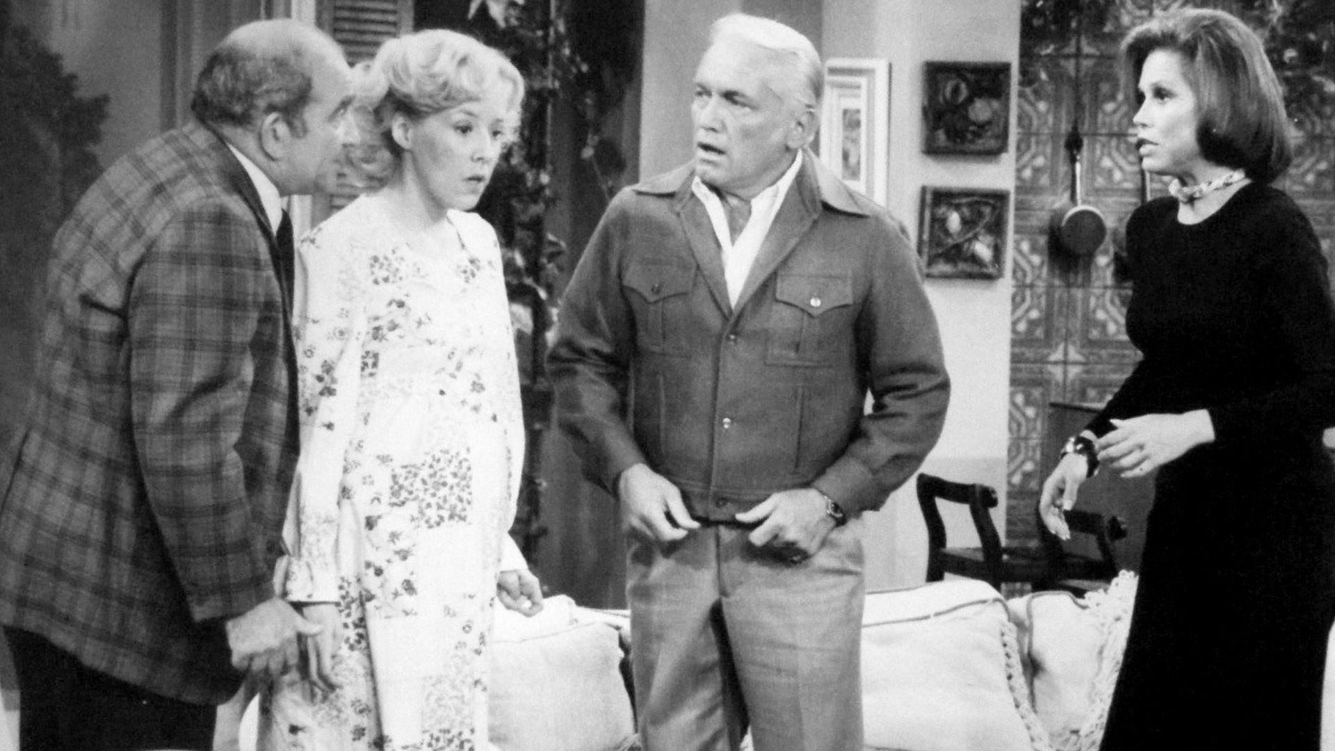 Photo from The Mary Tyler Moore Show.  Mary gives a dinner party that winds up as a birthday party when Georgette Baxter goes into labor during the dinner.  From left: Ed Asner (Lou Grant), Georgia Engel (Georgette Baxter), Ted Knight (Ted Baxter) and Mar