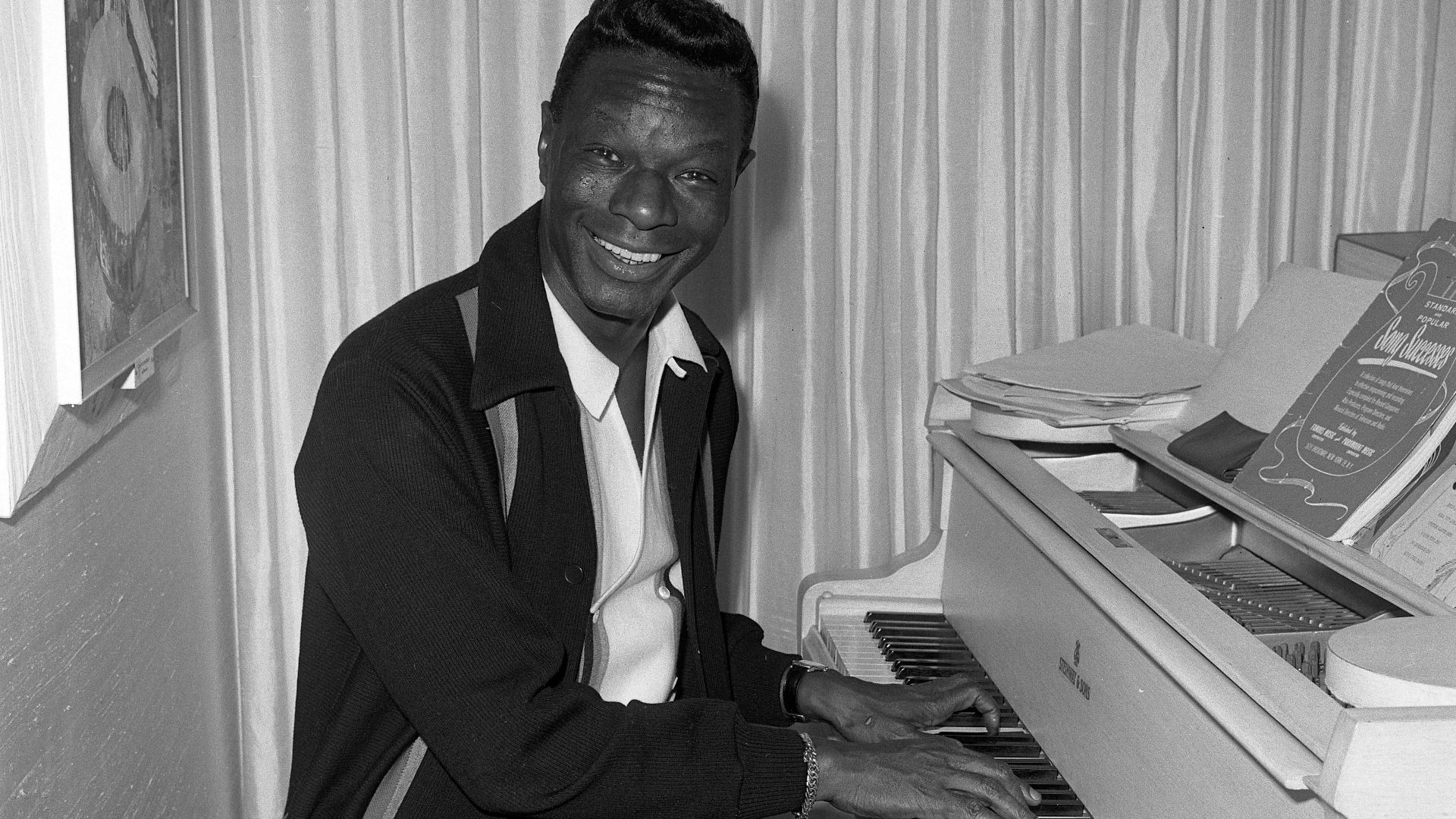 CELEBRITY AT HOME—Nat (King) Cole at the piano in his Wilshire district home [Los Angeles] reflects the casual personality familiar to millions from his stage, night club, television and film appearances.