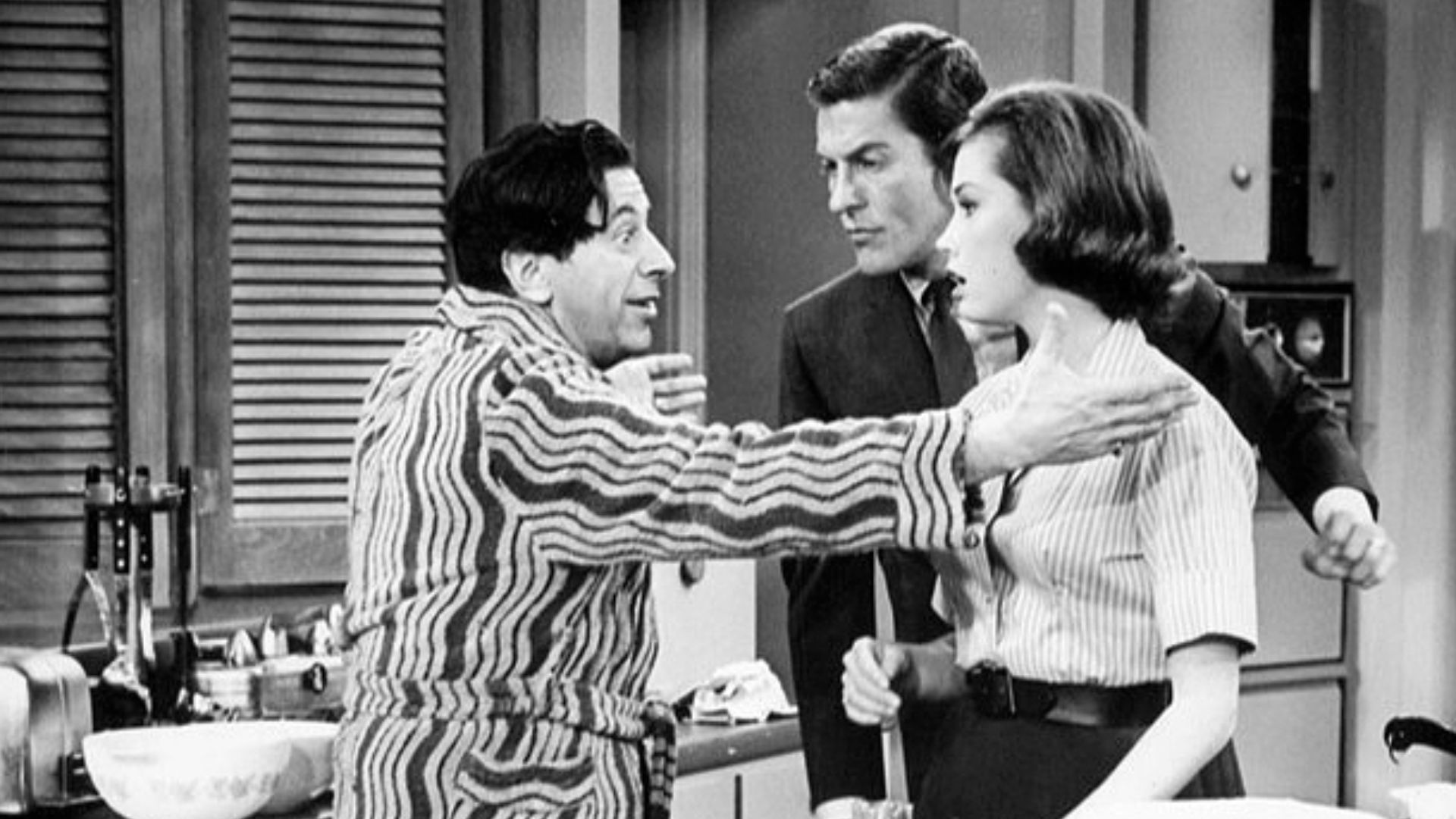 Publicity photo from The Dick Van Dyke Show. Pictured are Buddy (Morey Amsterdam) and Laura (Mary Tyler Moore) and Rob (Dick Van Dyke) Petrie. When Buddy's wife, Pickles, goes out of town, Buddy becomes the Petrie's house guest.