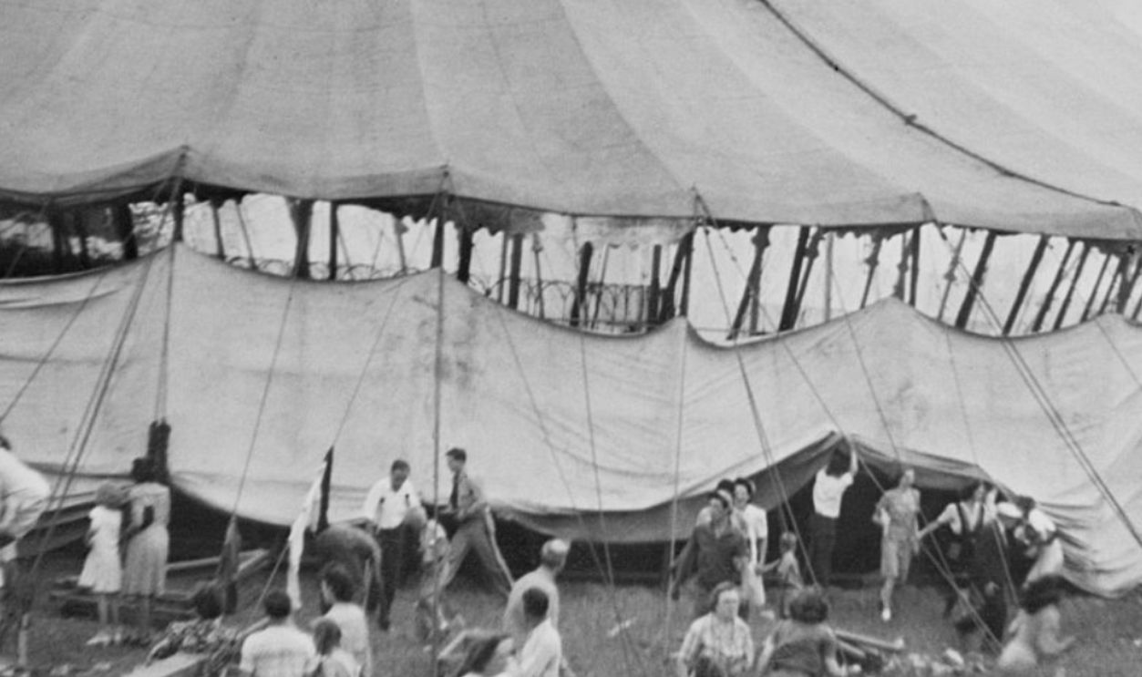 (Original Caption) 7/6/1944-Hartford, CT- As flames consumed the huge "big top", smoke can be seen at top of photo of the Ringling Brothers and Barnum and Bailey Circus this afternoon. People flee in terror from the menagerie tent (foreground). Some 10,000 persons- mostly women and children watching the performance in the big mig main tent, were tossed into milling, screaming panic as flames consumed the tent over them more than 127 are dead tonight