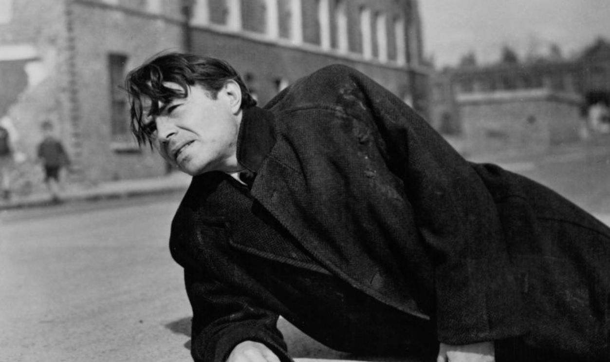 James Mason lies on the ground in a scene from the film 'Odd Man Out', 1947.