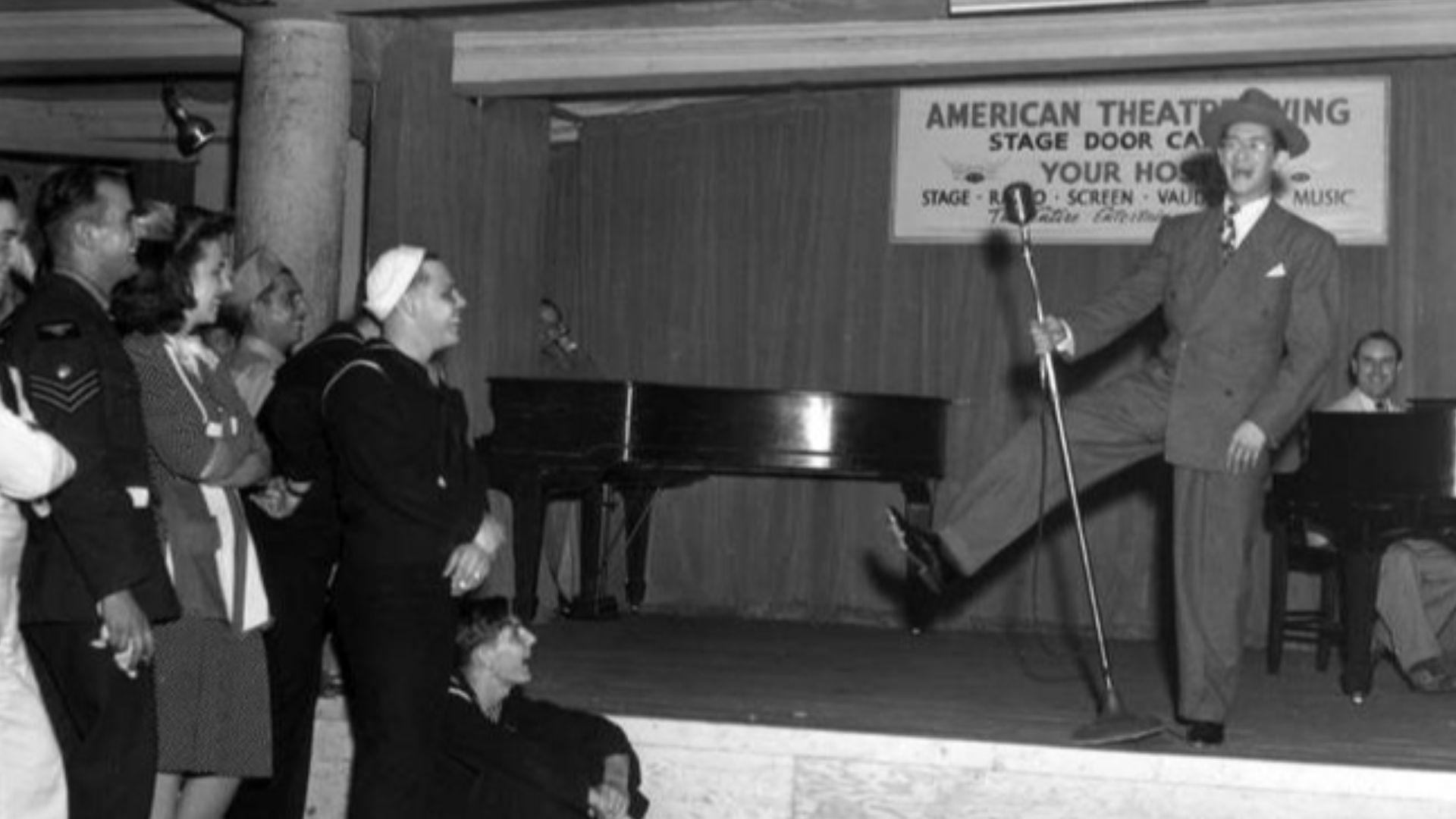 Comedian on stage, entertaining service members at the Stage Door Canteen in New York CityBroadway entertainment for the armed forces of all nations at the Stage Door canteen, run by the American Theater wing. Actors wait on soldiers and sailors who eat a