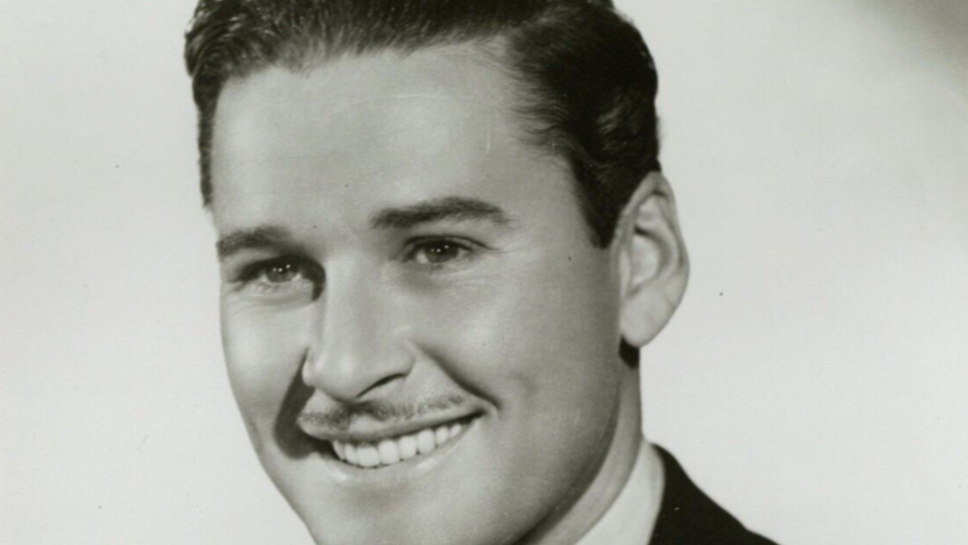 This is a publicity photo, circulated for publicity, of Errol Flynn, published in 1936 without copyright notice, qualifying it under public domain.
