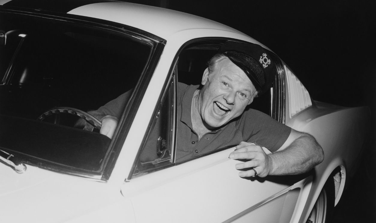 Getty Images - 1410885213 - Actor Alan Hale Jr., the Skipper from television show Gilligans Island, is shown smiling while leaning out the open window of a 1965 Ford Shelby GT350 Mustang in Los Angeles, California.