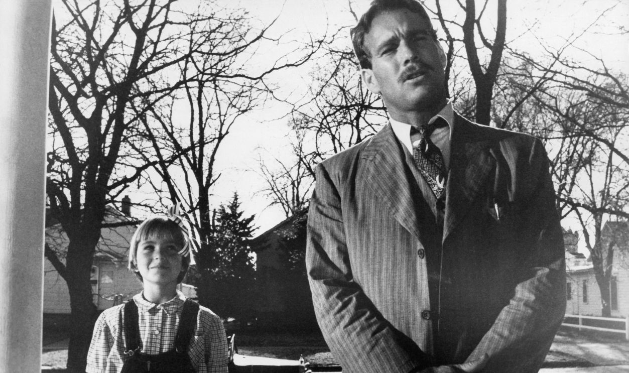 Ryan O'Neal and Tatum O'Neal standing at a door waiting for a response in a scene from the film 'Paper Moon', 1973.