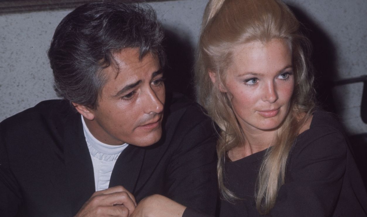 May 1968: Married American actors John Derek and Linda Evans sit together in close proximity during an Emmy Awards ceremony. Evans wears her long blonde hair in a bouffant at the back.