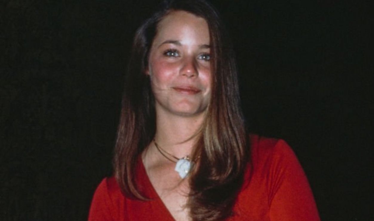 American actress Susan Dey, wearing a long-sleeved red dress, holding a gold purse, United States, 1975.