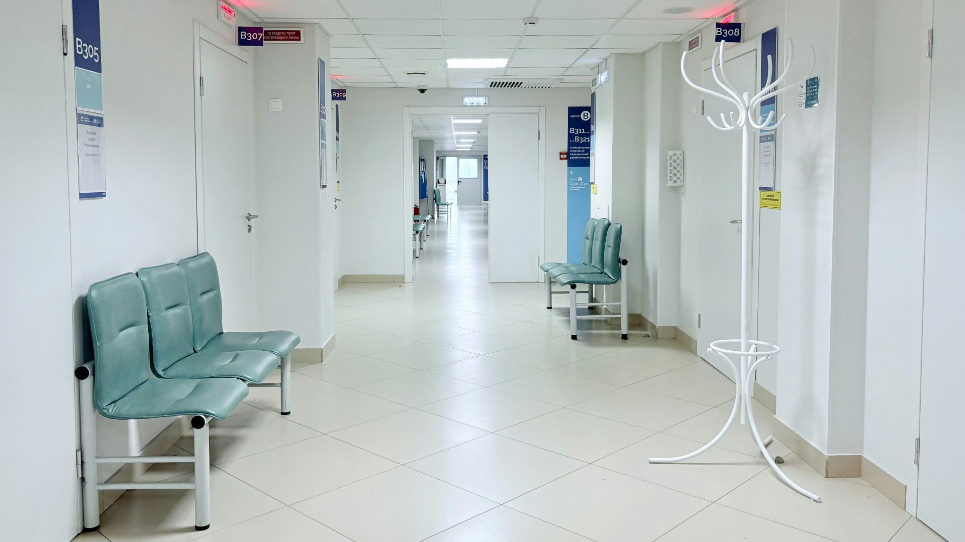 Empty hospital corridor with benches and doors