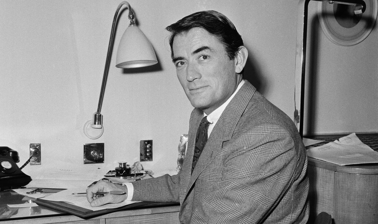 Actor Gregory Peck (1916-2003) writing at his desk in London while promoting the film 'On The Beach', December 22nd 1959. 