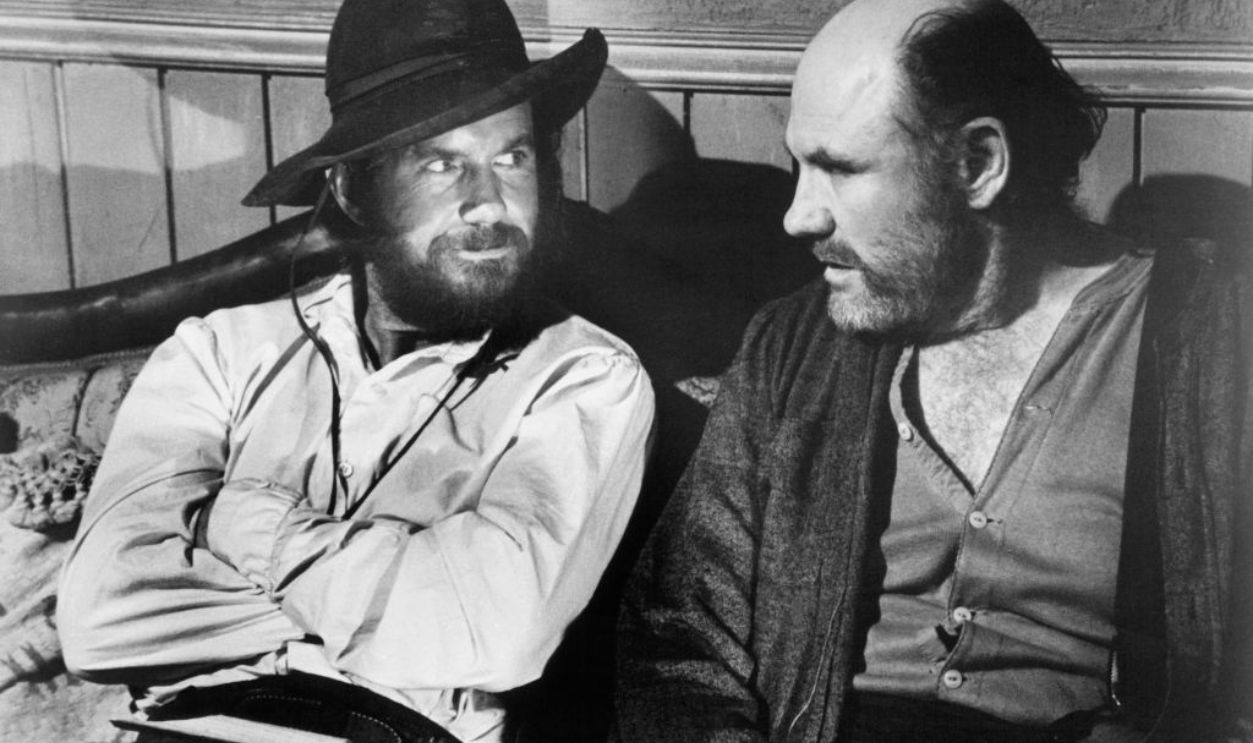 Cliff Robertson and RG Armstrong find relaxation in a scene from the film 'The Great Northfield Minnesota Raid', 1972. 
