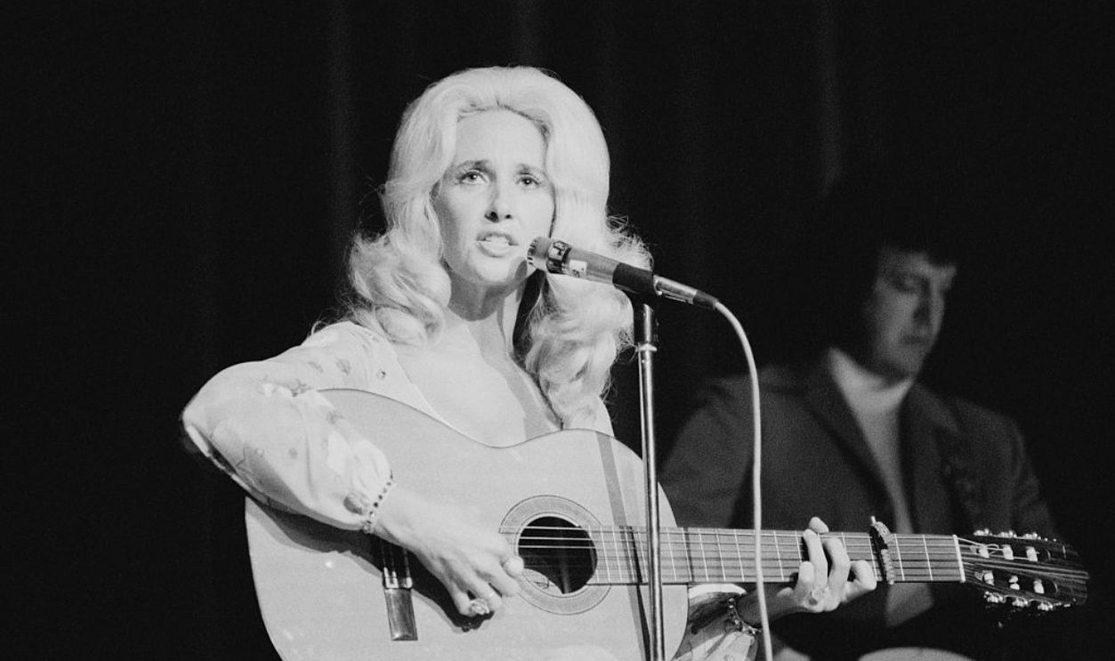 American country music singer-songwriter Tammy Wynette (1942 - 1998) performing at the Hammersmith Odeon, London, June 1975.