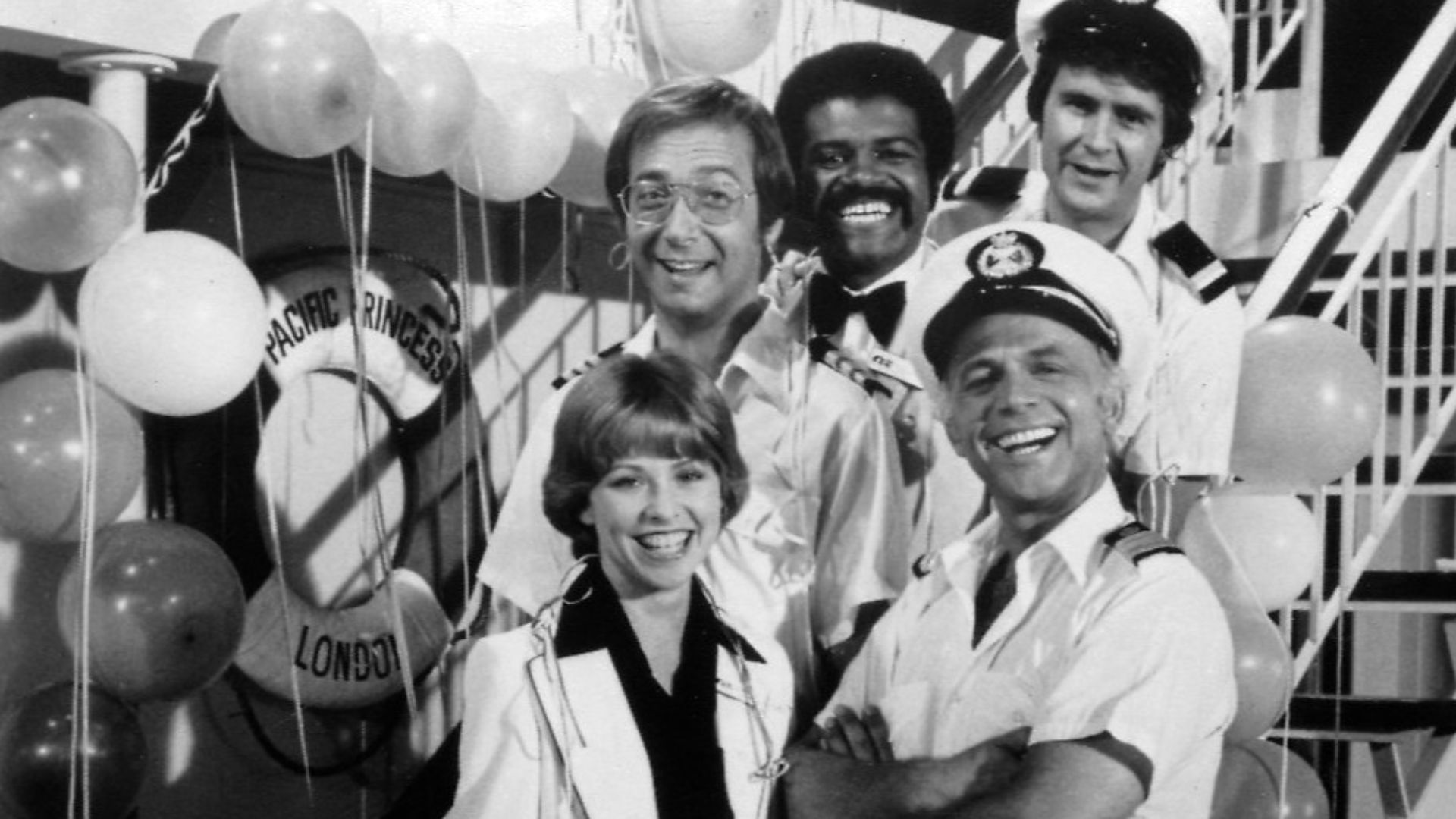 Publicity photo of cast for The Love Boat series premiere. Shown are Julie (Lauren Tewes), Captain Stubing (Gavin MacLeod), Doctor Bricker (Bernie Kopell), Isaac (Ted Lange), and Gopher (Fred Grandy).
This photo was produced prior to 1978 and has no copyr