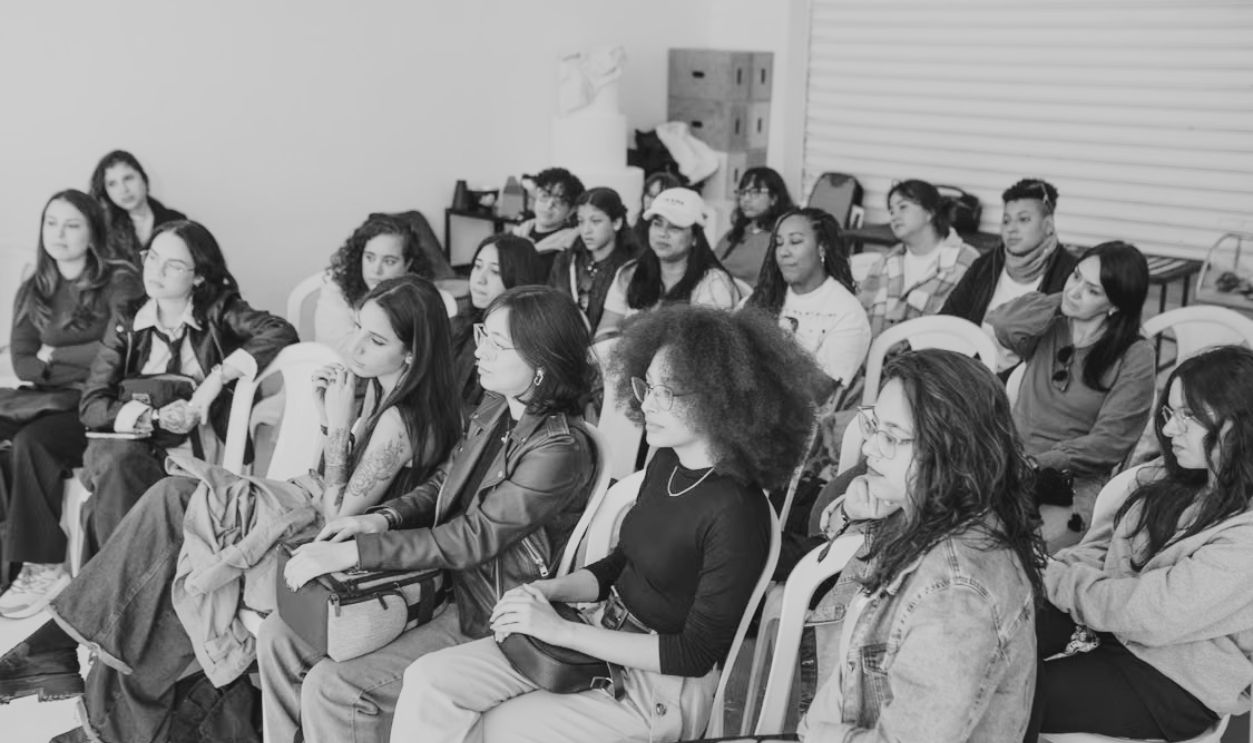 A diverse group of adults attentively listening during an indoor workshop session