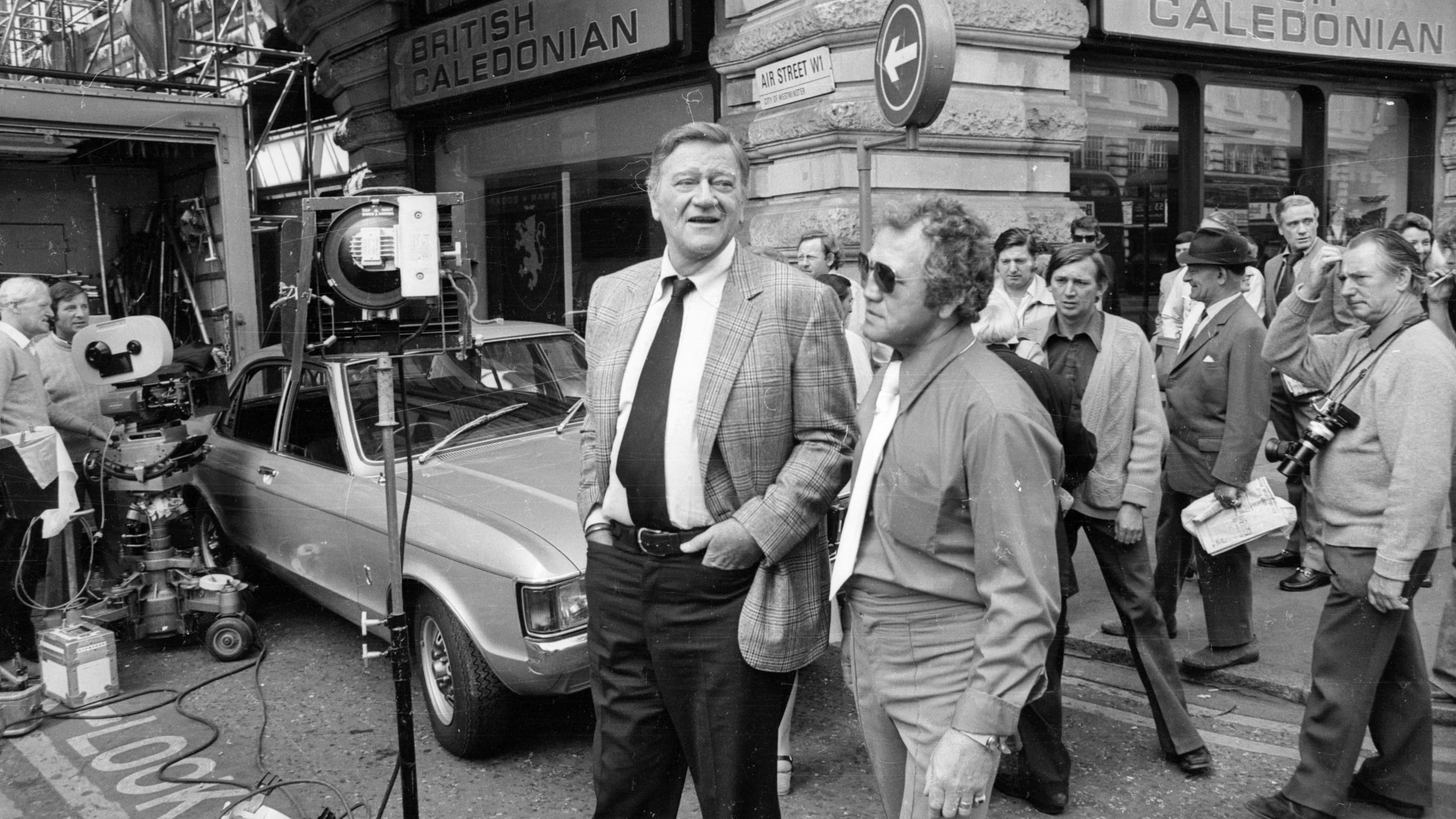 John Wayne filming 'Brannigan' in London's Piccadilly, outside the British Caledonian offices.