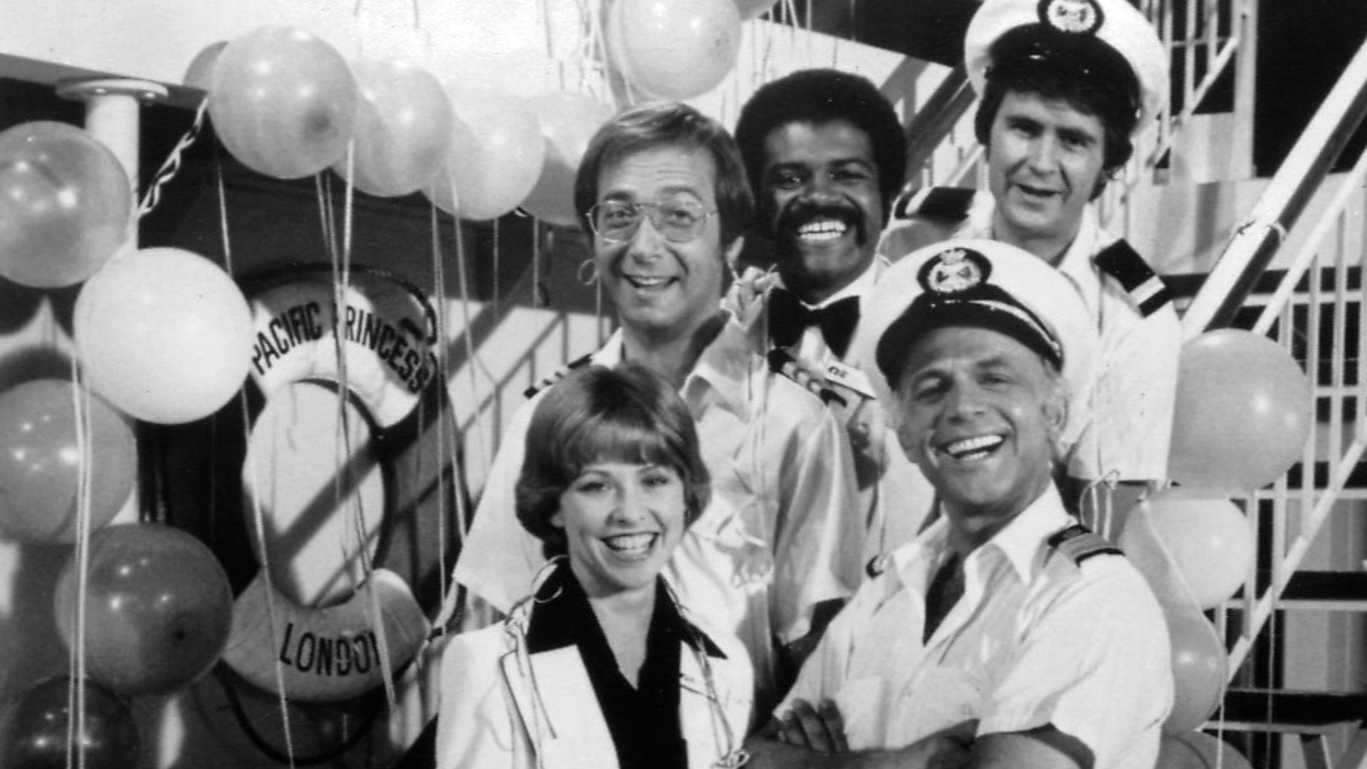 Publicity photo of cast for The Love Boat series premiere. Shown are Julie (Lauren Tewes), Captain Stubing (Gavin MacLeod), Doctor Bricker (Bernie Kopell), Isaac (Ted Lange), and Gopher (Fred Grandy).
This photo was produced prior to 1978 and has no copyr