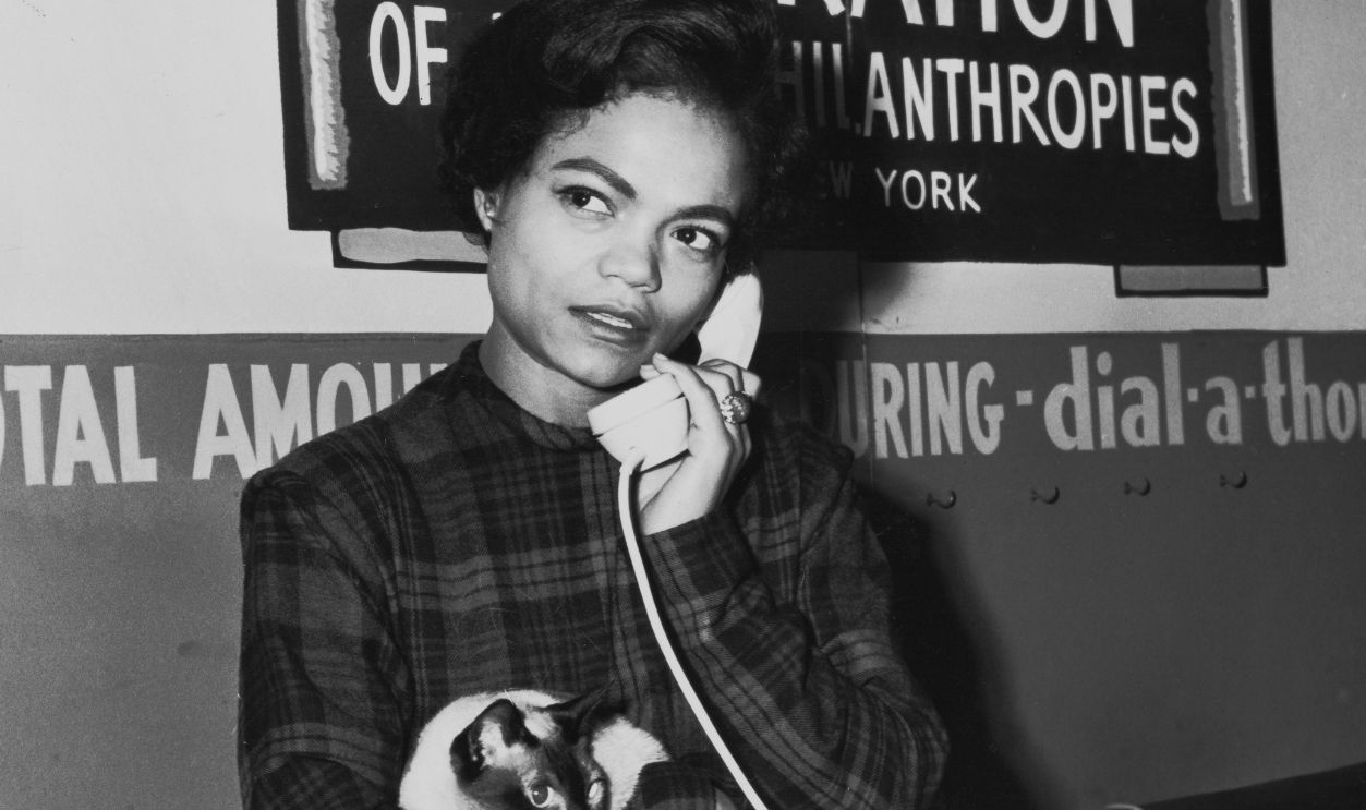 American singer and actress Eartha Kitt (1927 - 2008) holding her cat as she takes donations by phone for the New York Federation of Jewish Philanthropies during a telethon, circa 1960.