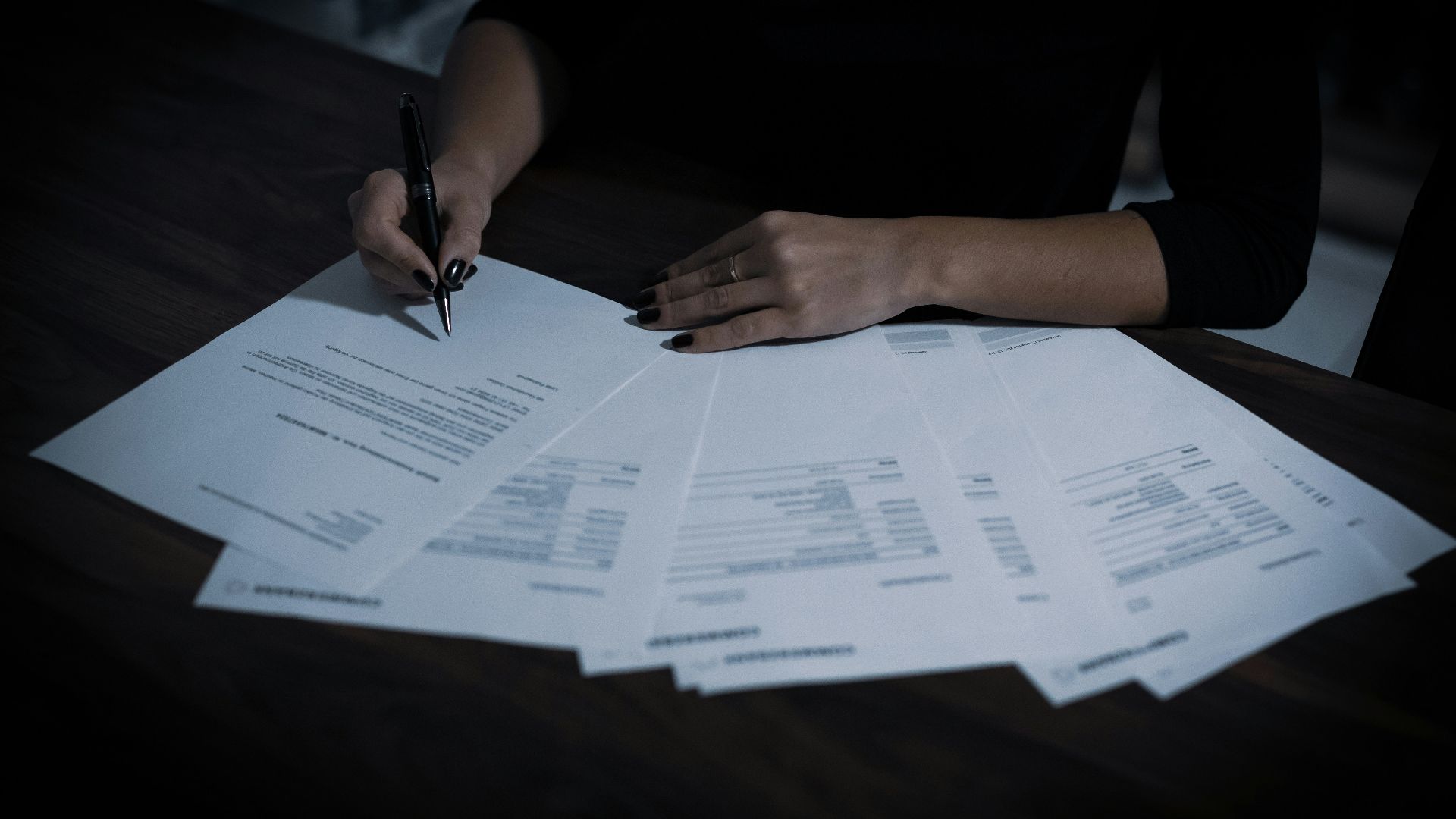 a woman sitting at a table with lots of papers