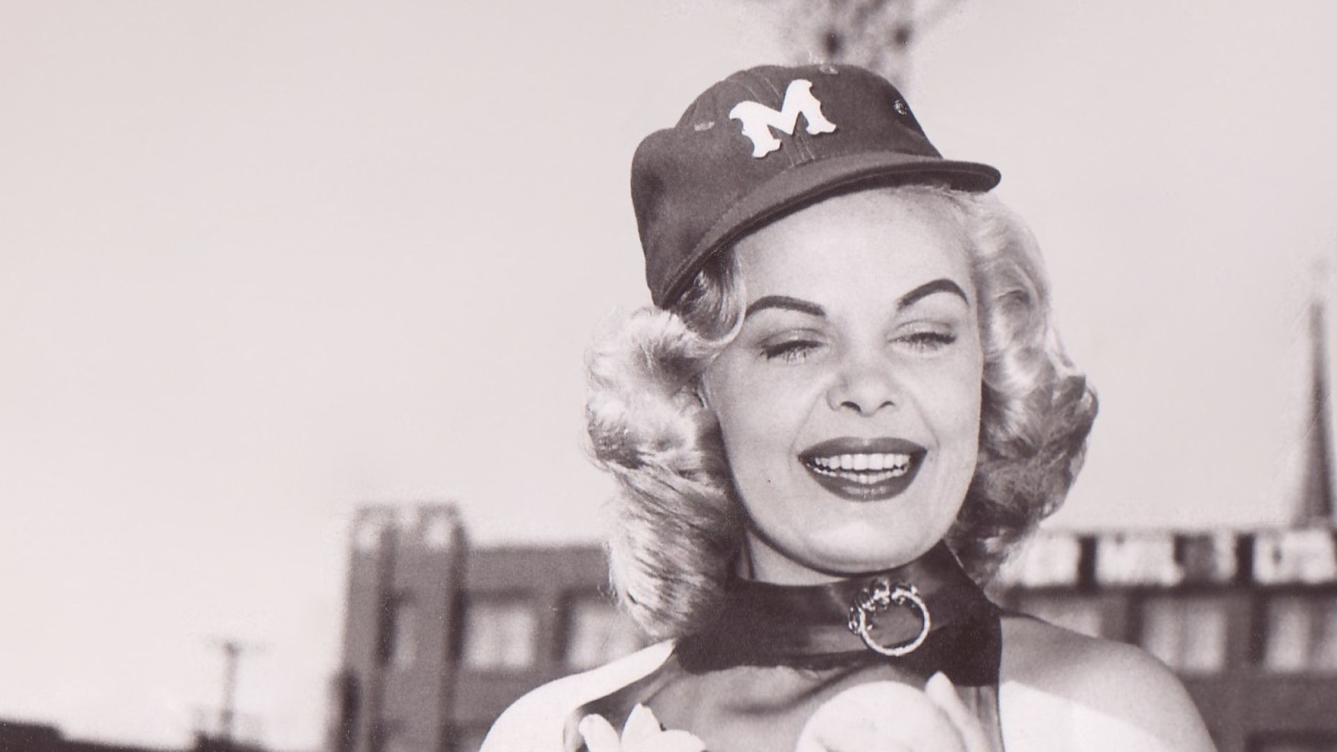 Fred Kipp is teaching actress Cleo Moore how to hold a baseball.