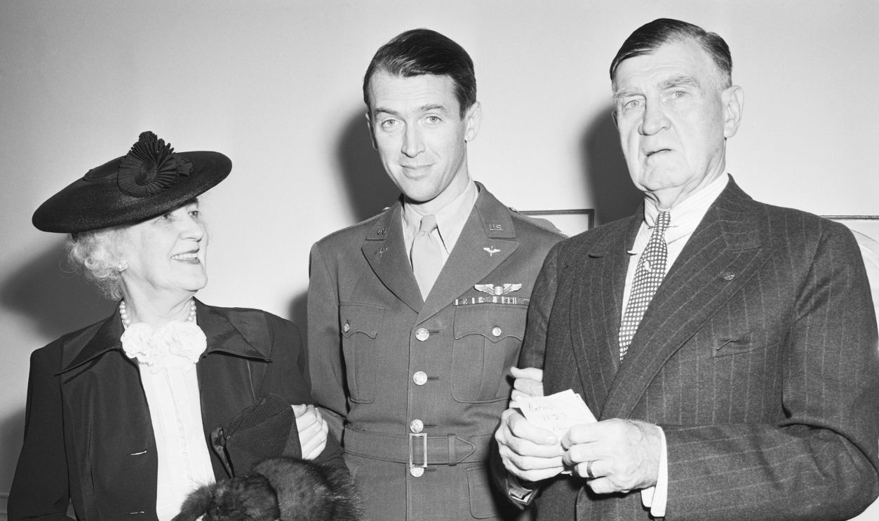 New York-Just like any serviceman returning from the war, Colonel James Stewart was greeted by his proud parents, who journeyed from Indiana, PA, to see their son after his arrival aboard the Queen Elizabeth. A veteran of a year and a half overseas with the 8th Air Force, Colonel Stewart, in his last command, was senior officer over approximately 9,000 men. Here he is shown with his parents at the St. Regis Hotel.