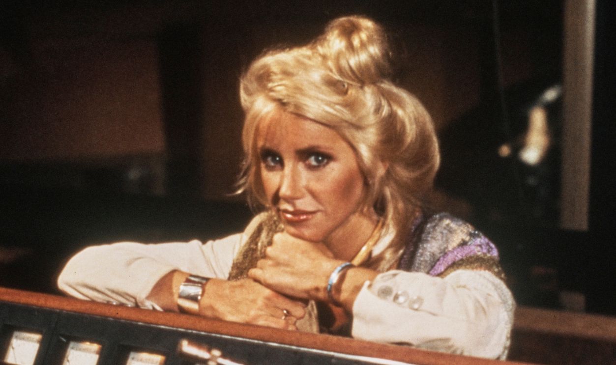 American actress Suzanne Somers posed leaning on a mixing console in a recording studio, circa 1980