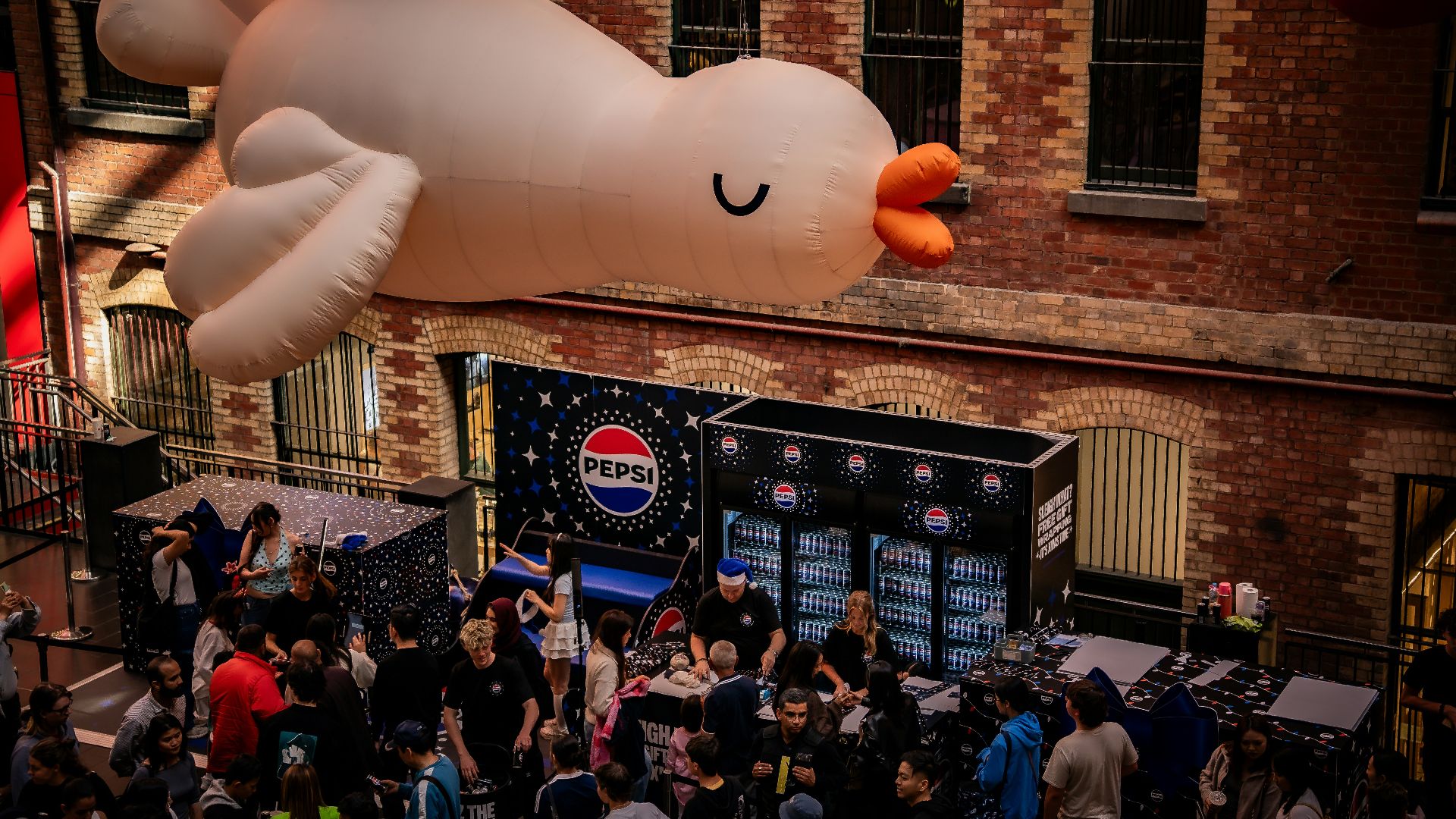 Giant inflatable bird floats over a crowded street event