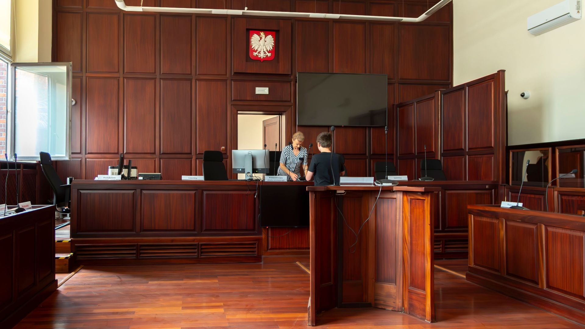 Spacious Polish courtroom with wooden panels and furniture located in Wrocław, Lower Silesia.