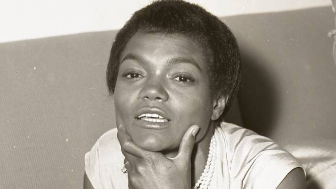 Eartha Kitt visit to Israel, wearing a white dress, lying on a bed