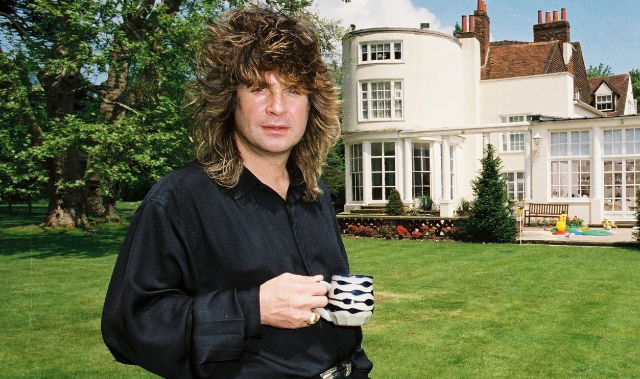 Black Sabbath singer Ozzy Osbourne holding a cup of tea in the garden of his home. May 1988