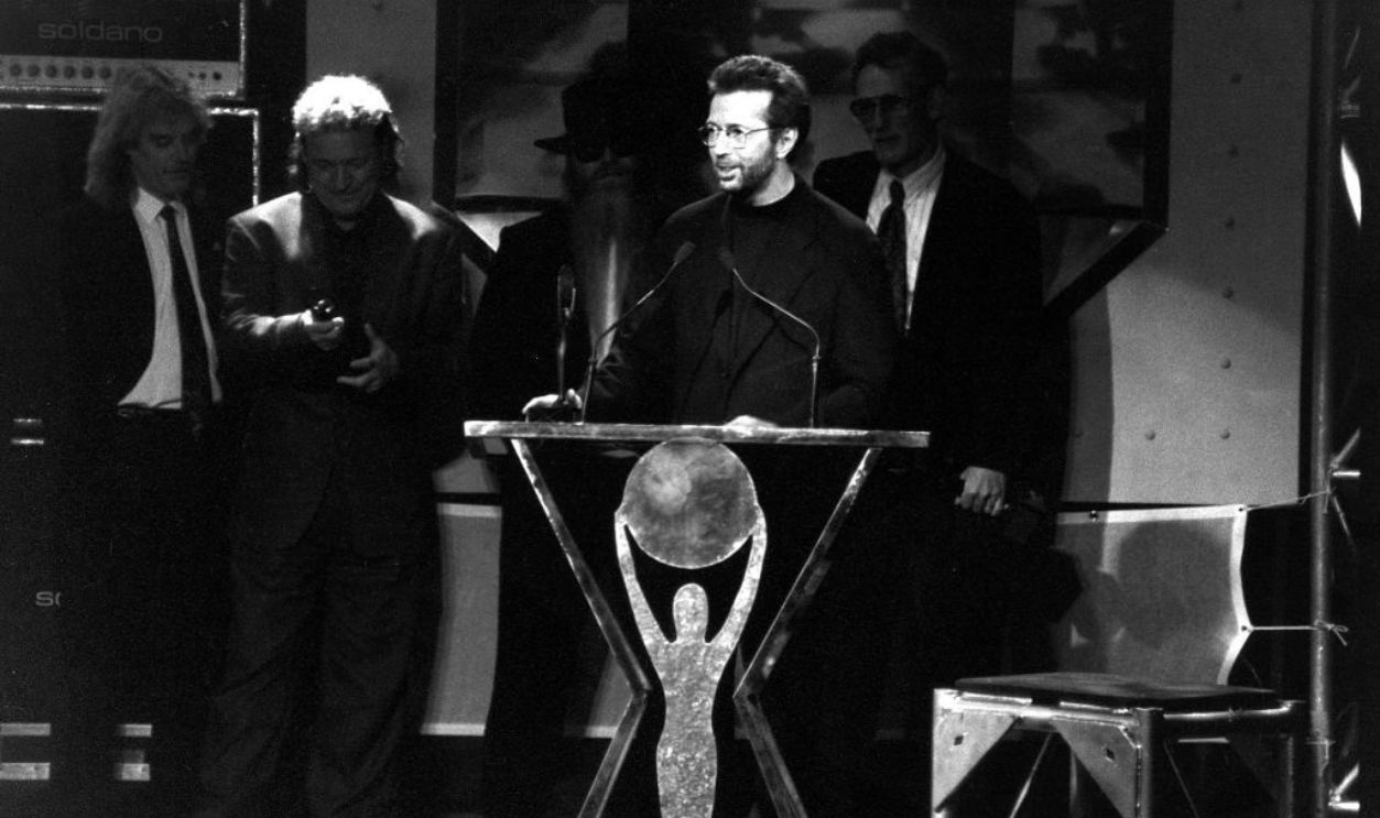 UNITED STATES - AUGUST 28: Eric Clapton accepts induction into the Rock and Roll Hall of Fame for his 60's supergroup: Cream, while fellow members Jack Bruce and Ginger Baker look on. The 1993 ceremonies were held in Los Angeles for the first time.