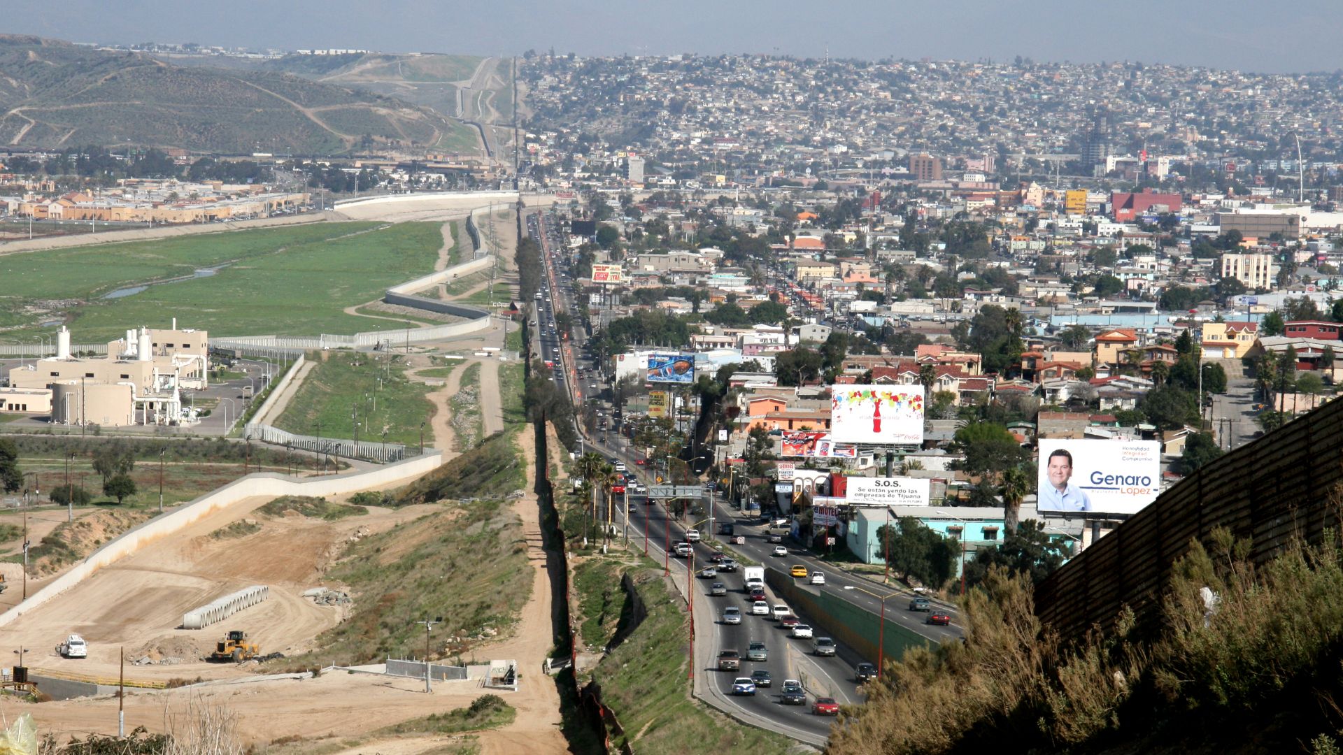 A small fence separates densely-populated Tijuana, Mexico, right, from the United States in the Border Patrol's San Diego Sector. Construction is underway to extend a secondary fence over the top of this hill and eventually to the Pacific Ocean.