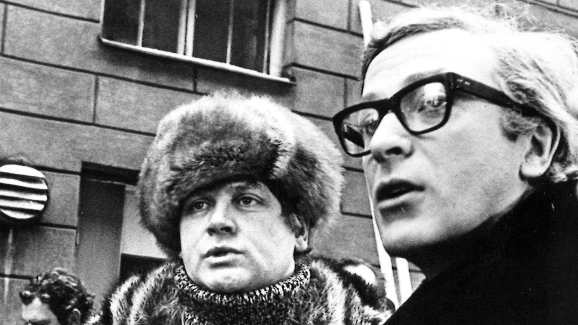Photograph of the film producer André de Toth, director Ken Russell, and actor Michael Caine in Helsinki during the cinematography of Billion Dollar Brain, here on Sofiankatu, near the old police station.