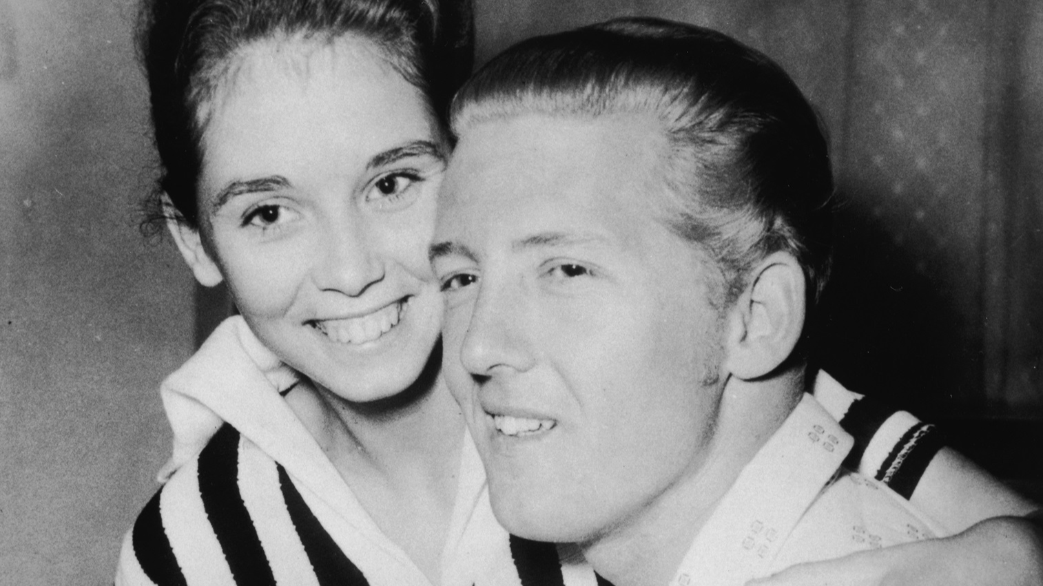 Jerry Lee Lewis holds his second cousin and third wife Myra Brown in his lap at a press conference - 1958.