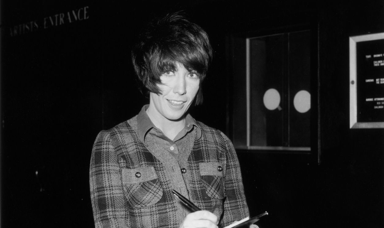 American actor and comedian Lily Tomlin writing on a clipboard at a party in honor of American singer and composer, Jim Webb.