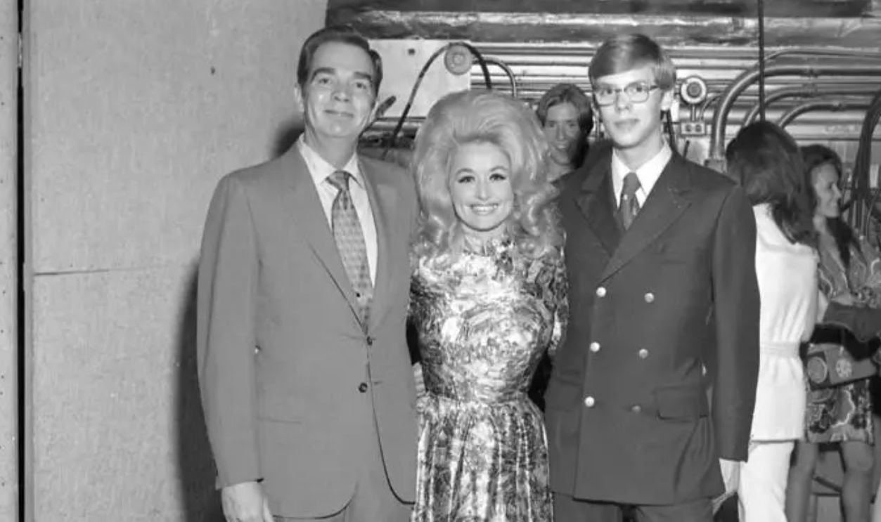 Country singer songwriter Dolly Parton poses for the camera with DJs backstage at the Grand Ole Opry circa 1970 in Nashville, Tennessee.