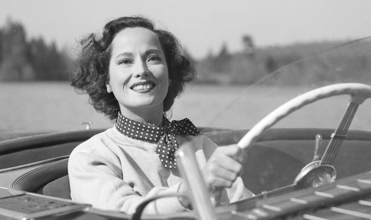 Merle Oberon, on location for her latest picture, Night Song, sits behind the wheel of a motorboat.Merle Oberon, on location for her latest picture, Night Song, sits behind the wheel of a motorboat.