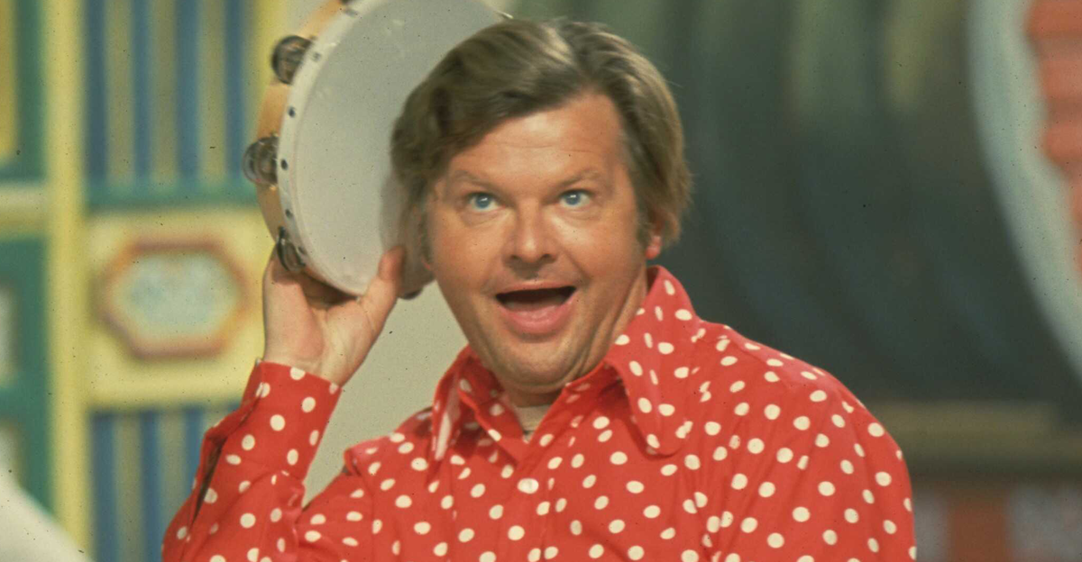 Comedian Benny Hill performing with a tambourine on set, circa 1971. 