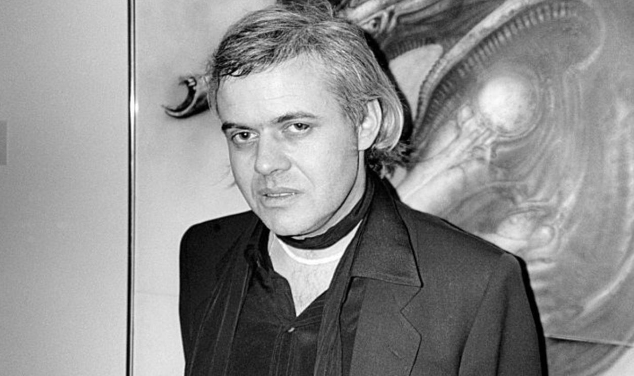 Portrait of Swiss Surrealist painter HR Giger as he poses in front one of his 'Alien' works, New York, New York, April 12, 1980.