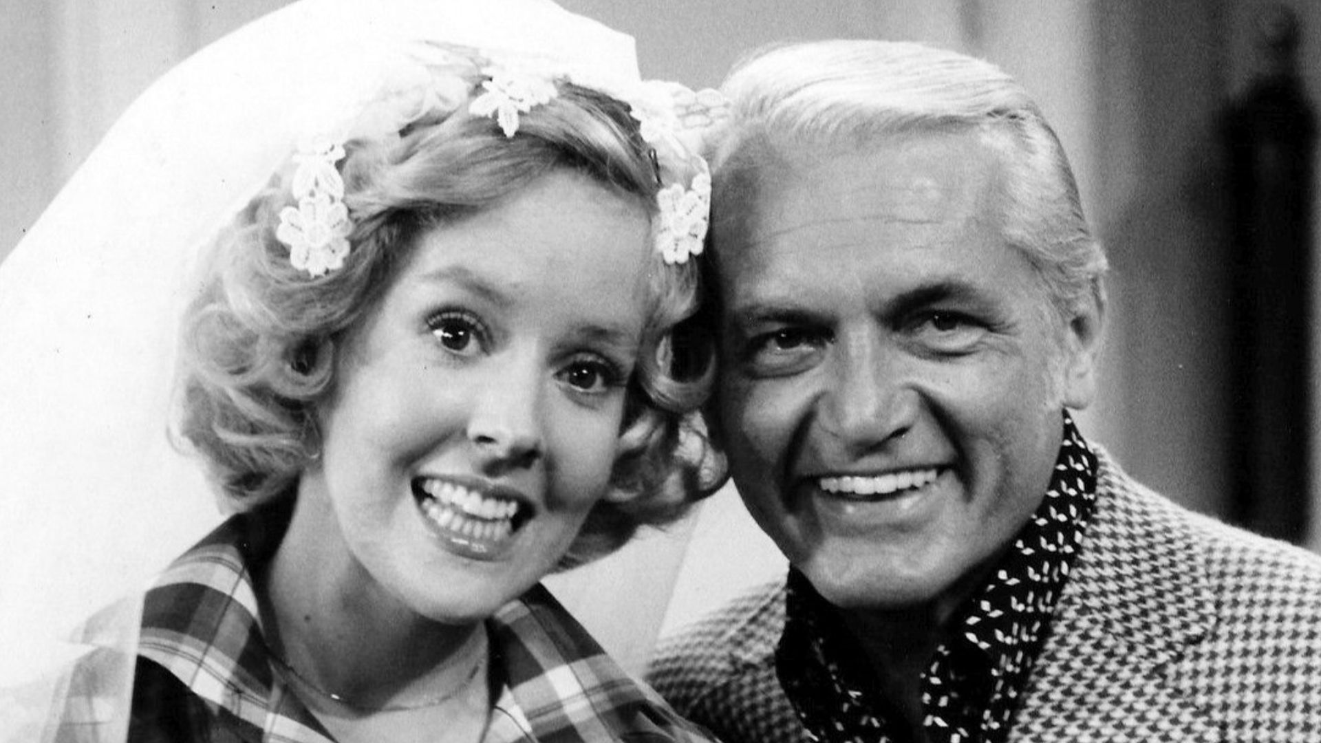 Photo of Georgia Engel and Ted Knight from the television program The Mary Tyler Moore Show.  Georgette Franklin (Engel) and anchorman Ted Baxter (Knight) have just been married at an impromptu ceremony at Mary Richard's (Tyler Moore) apartment.