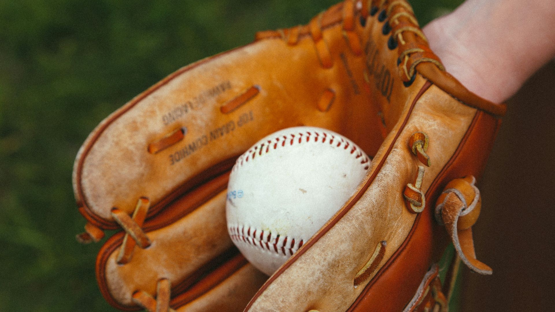 brown leather baseball mitt with white baseball