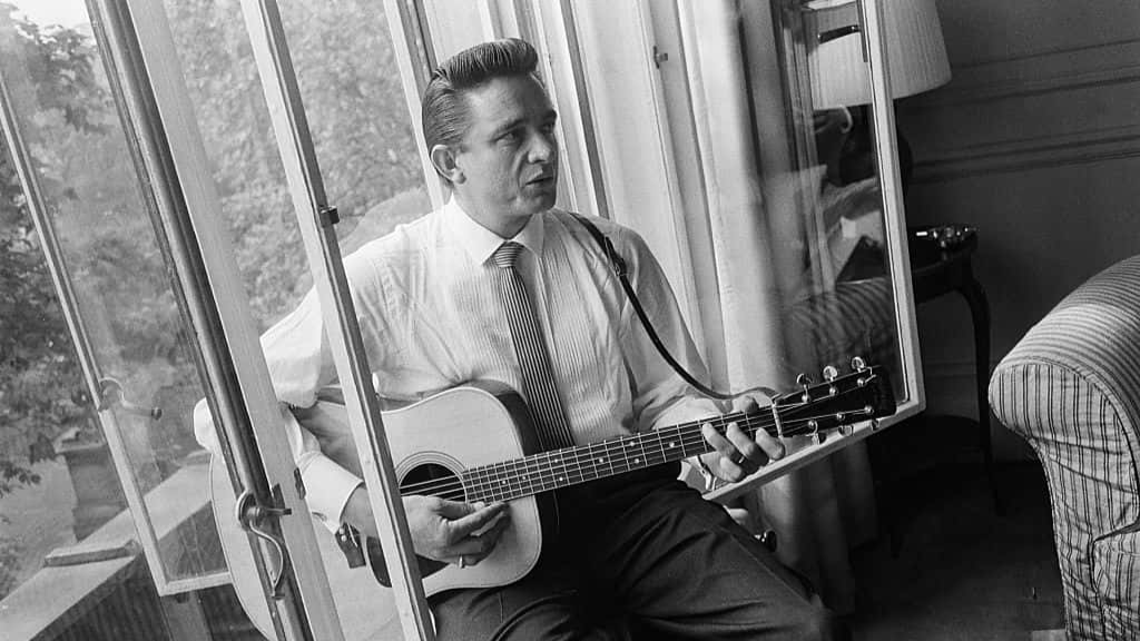 Johnny Cash in London, Savoy Hotel, playing a guitar