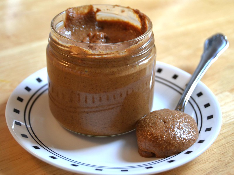 Close-up Photo of Almond Butter Jar in white plate placed on a wooden table