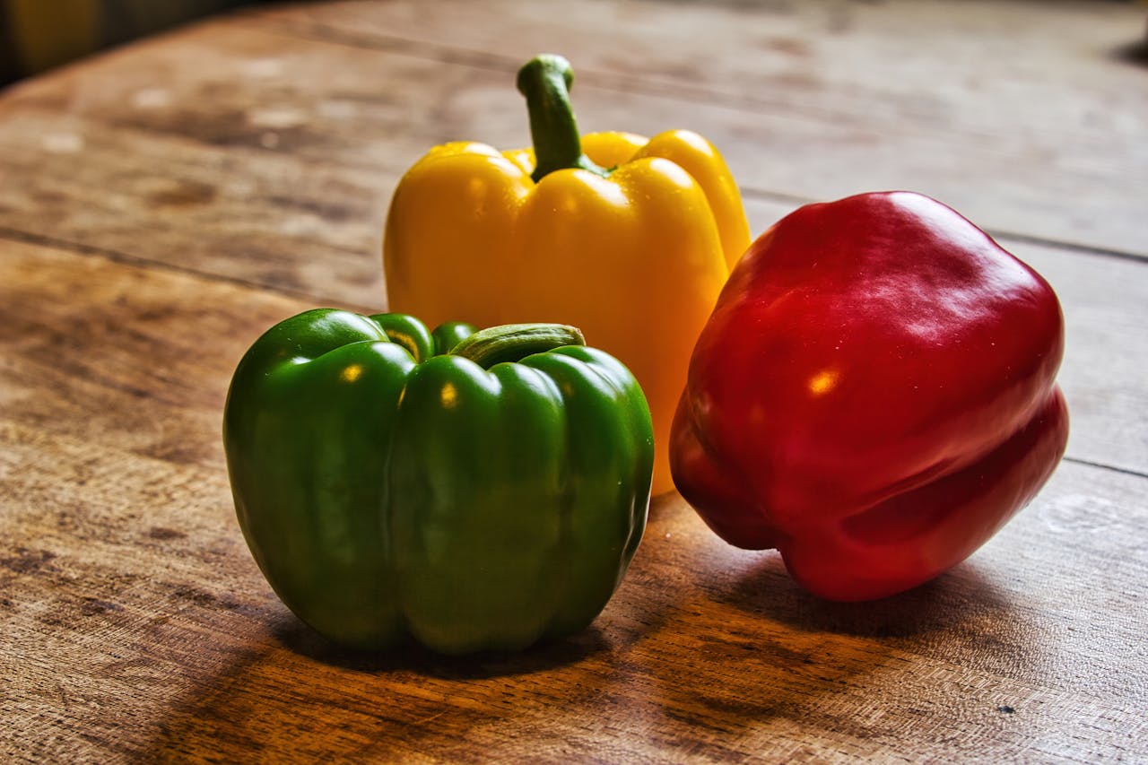 Close-up Photo of Colorful Bell Peppers on a Wooden Surface