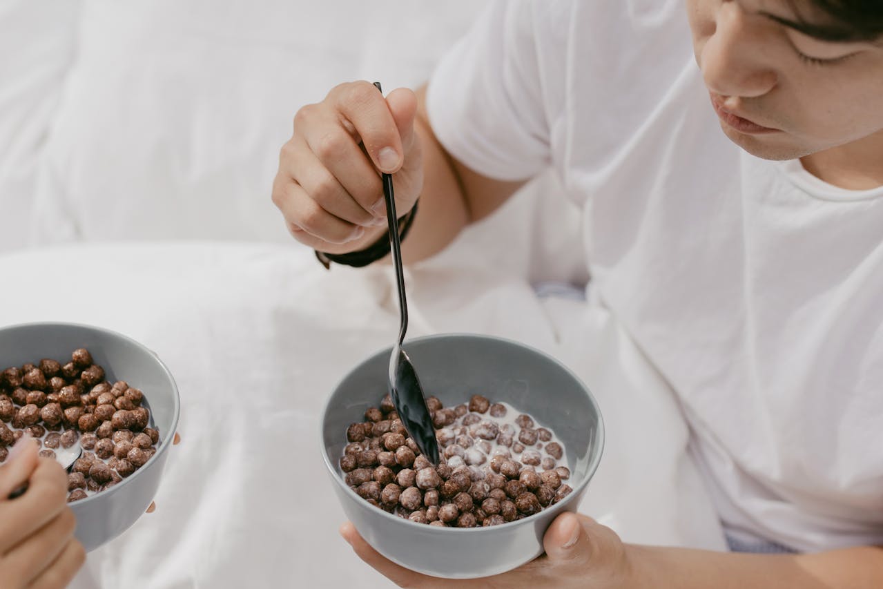 High-Angle Shot of a Man in a white t-shirt Eating Chocolate Cereal
